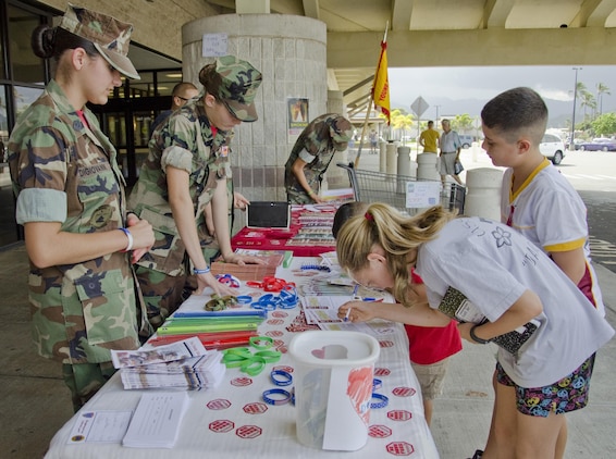 The Pyramid Rock Young Marines encourage military family members to sign pledges to be drug-free at the Marine Corps Base Hawaii commissary, Oct. 27, 2013. The Pyramid Rock Young Marines held a drive for recruitment and collecting canned goods while handing out information about Red Ribbon Week. (U.S. Marine Corps photo by Kristen Wong)