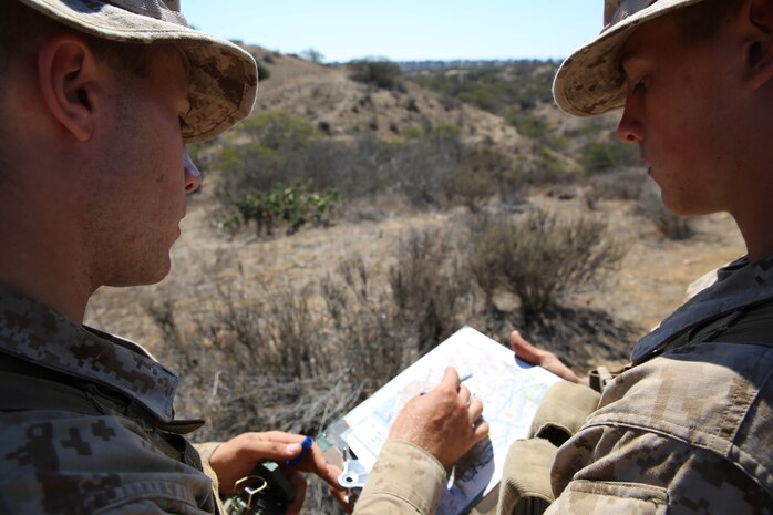 Recruits (left to right) Guy T. Hutches and Benjamin I. Smith find their next navigation is on the map during the Land Navigation Course at Edson Range.  Recruits must find all five of their navigation points in a time limit of four hours.