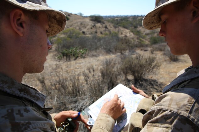 Recruits (left to right) Guy T. Hutches and Benjamin I. Smith find their next navigation is on the map during the Land Navigation Course at Edson Range.  Recruits must find all five of their navigation points in a time limit of four hours.