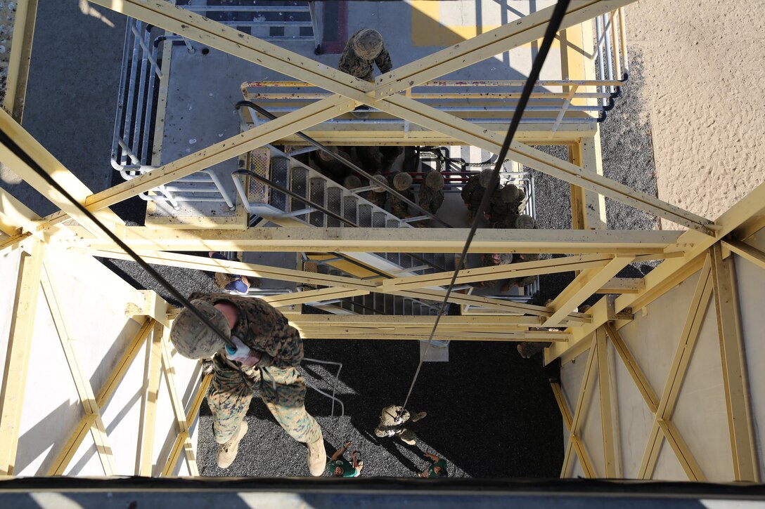 Recruit D. A. Ballard (left) and Recruit B. D. Austin (right), Platoon 3243, Company L, 3rd Recruit Training Battalion, rappel down the “hell hole” during the rappel tower aboard the depot, Oct. 18.  The rappel tower consists of a 15-foot fast rope rappel station, a 60-foot side wall rappel station, and a 60-foot center hole (hell hole) rappel station.