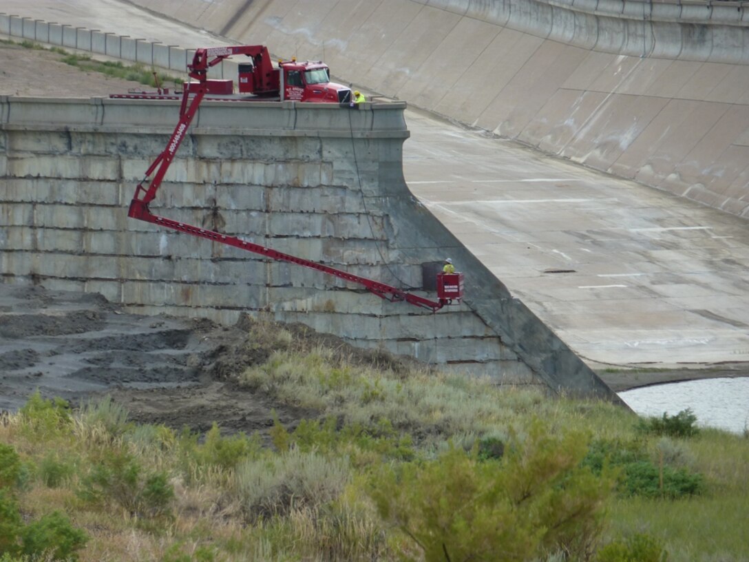A contractor inspects retaining walls after six contracts were awarded in 2012 to repair damages at Fort Peck Dam. They include repair of gates, the spillway slab, plunge pool, recreation area roads and drains, the spillway access road and associated drains, rehabilitation of eight emergency gate controls and the repair of relief wells and the horizontal outfall pipes.  