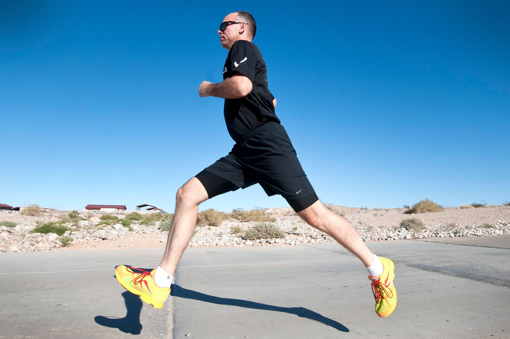 Master Sgt. Luke McCarthy, 99th Security Forces Squadron Charlie One flight chief, sprints at the end of his running route on a back road located in Area 2 during a training workout Oct. 31, 2013, at Nellis Air Force Base, Nev. McCarthy trains five days a week for three to five miles during each session and supports Life of a Warrior initiative warrior trained fitness work outs as a fitness cadre. The Life of a Warrior initiative challenges Airmen to grow in the physical, mental, social and spiritual areas of their lives and to invest in positive growth rather than a destructive lifestyle. (U.S. Air Force photo by Staff Sgt. Christopher Hubenthal)  