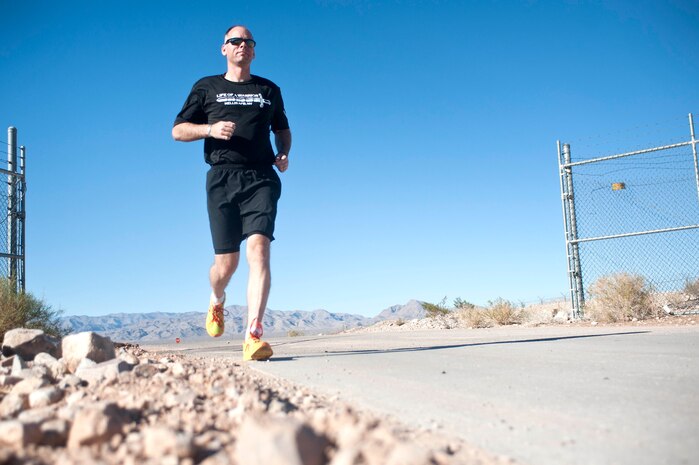 Master Sgt. Luke McCarthy, 99th Security Forces Squadron Charlie One flight chief, runs on a back road located in Area 2 during a training workout Oct. 31, 2013, at Nellis Air Force Base, Nev. McCarthy trains five days a week for three to five miles during each session and supports Life of a Warrior initiative warrior trained fitness work outs as a fitness cadre. The Life of a Warrior initiative challenges Airmen to grow in the physical, mental, social and spiritual areas of their lives and to invest in positive growth rather than a destructive lifestyle. (U.S. Air Force photo by Staff Sgt. Christopher Hubenthal)