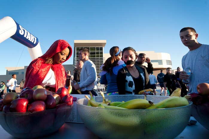 Service members and their families grab fruit and water after finishing the Halloween 5 kilometer run at the Warrior Fitness Center Oct. 31, 2013, at Nellis Air Force Base, Nev. Runners were able to dress in costumes, win prizes and compete in a best costume competition. The run was also in recognition of National Disability Employment Awareness Month.  (U.S. Air Force photo by Staff Sgt. Christopher Hubenthal)