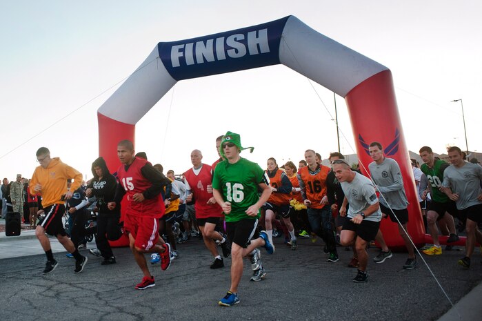 Service members and their families start the Halloween 5 kilometer run outside the Warrior Fitness Center Oct. 31, 2013, at Nellis Air Force Base, Nev. Runners were able to dress in costumes, win prizes and compete in a best costume competition. Service members and their families were also able to observe National Disability Employment Awareness Month with words from guest speakers involved with the Wounded Warrior Camp. (U.S. Air Force photo by Staff Sgt. Christopher Hubenthal)