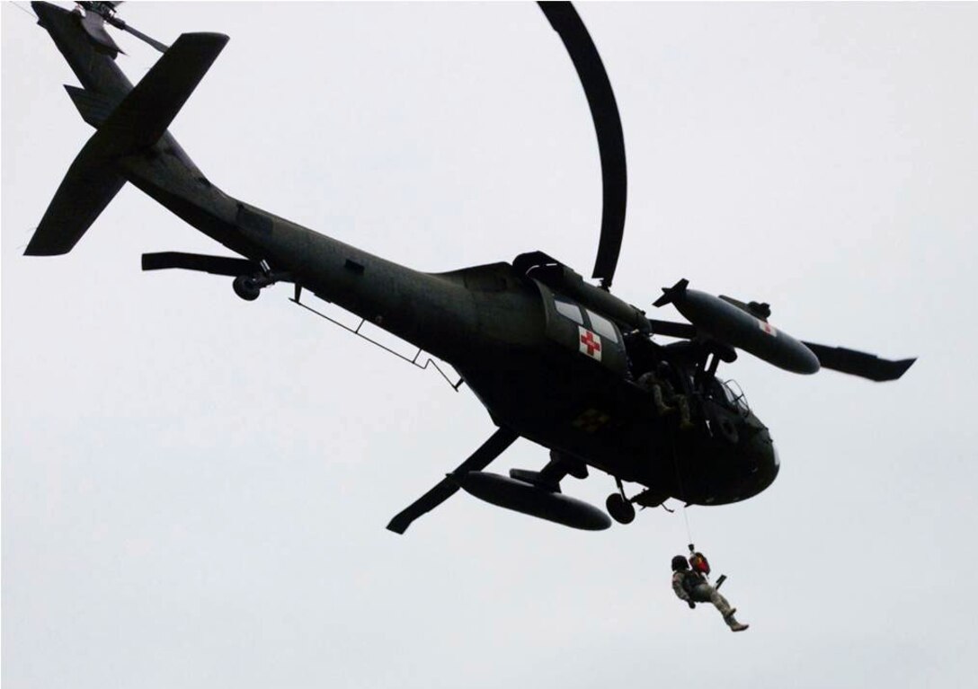 U.S. Army Staff Sgt. Matthew Reed, 1-228th Aviation Regiment, Joint Task Force-Bravo, is lowered from a HH-60 Blackhawk helicopter by U.S. Army Staff Sgt. Kyle Farnes during a live hoist training exercise in Puerto Castilla, Honduras, Oct. 30, 2013.  The 1-228th's "C" Company teamed up with Special Boat Team 22 as well as Honduran soliders to conduct the training.  (Photo by U.S. Army 1st Lt. Michael Pierce)