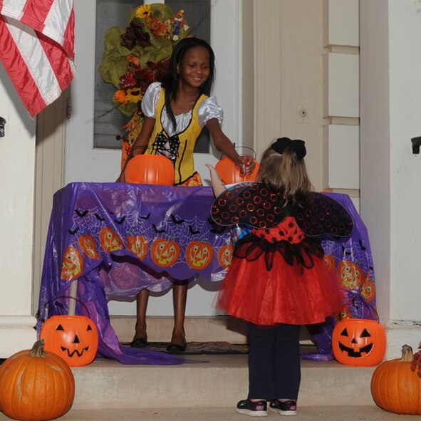 A child passes out candy on Halloween on Barksdale Air Force Base, La., Oct. 31, 2013. Barksdale Airmen decorated their houses in a festive theme and passed out candy to the children. (U.S. Air Force photo/Senior Airman Kristin High)