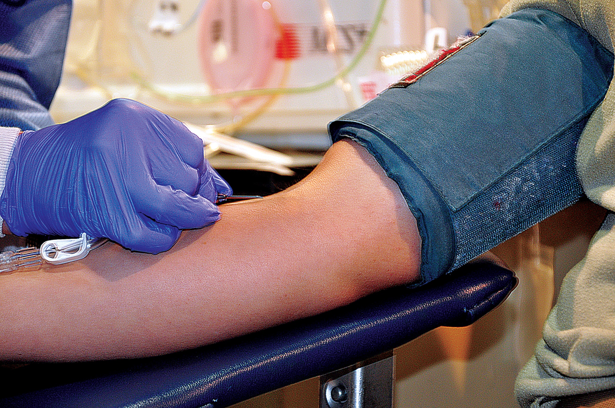 A United Blood Services technician inserts a needle into the vein of Airman 1st Class Zachary Warren, 90th Security Forces Group, Nov. 1, 2013, during a base-wide blood drive held in the Fall Hall Community Center, F.E. Warren Air Force Base, Wyo. (U.S. Air Force photo by Senior Airman Mike Tryon)