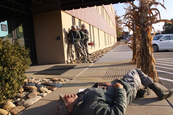 PITTSBURGH IAP ARS -- A three-man 911th Security Forces entry team takes cover before entering a building, while one Airman lay wounded from a gunshot sustained during a random shooting that claimed the lives of two other Airmen, during a routine training exercise, Oct. 29, 2013 at the Pittsburgh International Airport Air Reserve Station.  The training scenario’s premise was how Security Forces and base personnel would respond if confronted with an “active shooter.”  The Department of Homeland Security defines an “Active Shooter” as: an individual actively engaged in killing or attempting to kill people in a confined and populated area; in most cases, active shooters use firearms(s) and there is no pattern or method to their selection of victims. These training exercises are used to ensure airmen remain vigilant and are aware of the proper reporting procedures necessary to assist SFS personnel in eliminating possible threats. (U.S. Air Force photo by Master Sgt. Mark A. Winklosky)   