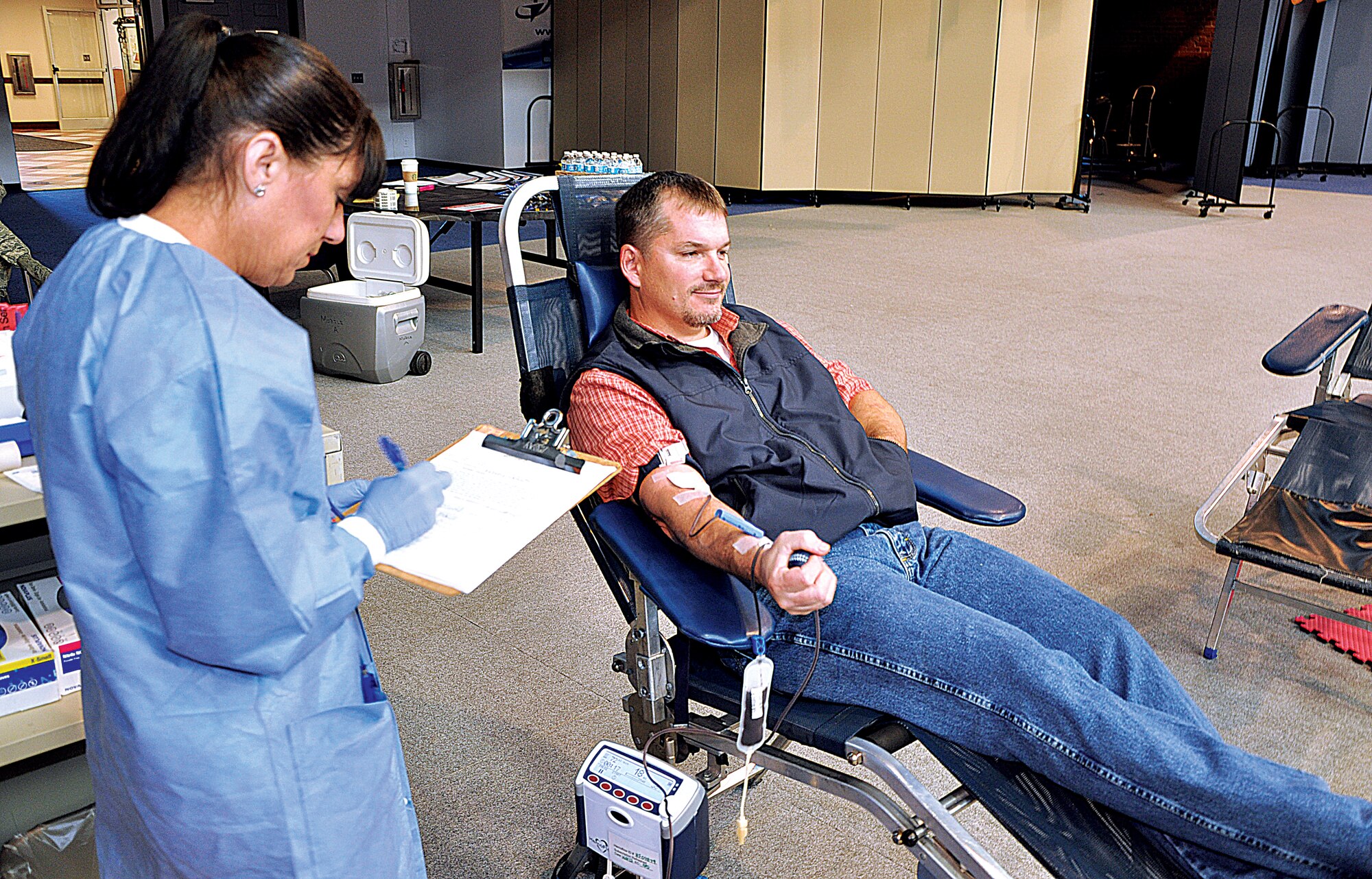 Dan Dial, 90th Missile Wing Freedom of Information Act and Privacy Act manager, donates blood Nov. 1, 2013, in the Fall Hall Community Center, F.E. Warren Air Force Base, Wyo., as a United Blood Services technician looks over his donation form. (U.S. Air Force photo by Senior Airman Mike Tryon)