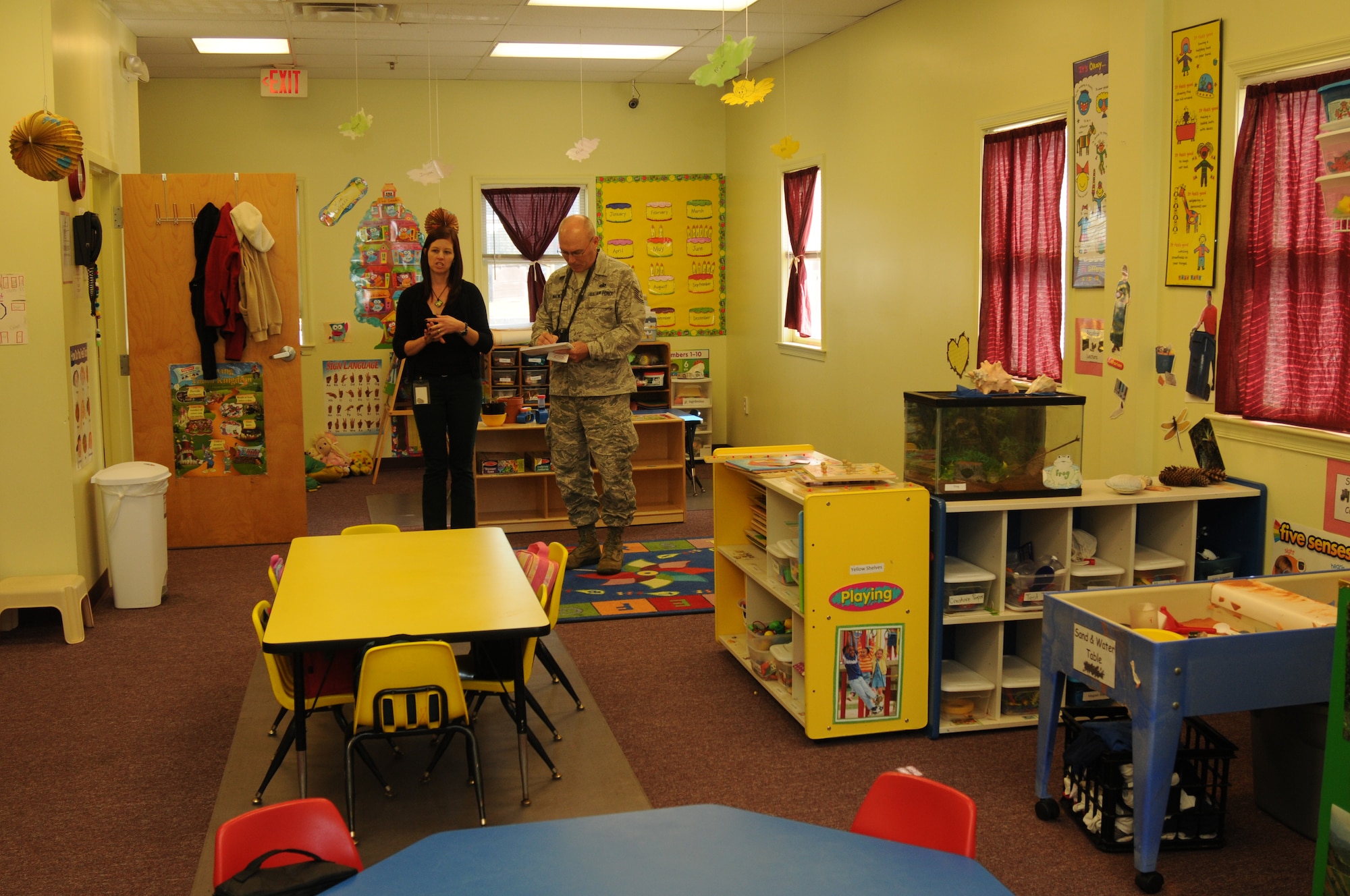 Jill Foster, assistant director, Tender Loving Kare Child Care & Learning Center, Newark, Del., discusses operations with U.S. Air Force Tech. Sgt. Benjamin Matwey, 166th Airlift Wing Public Affairs, during a facility tour Oct. 21, 2013. Families of Delaware National Guard members may enroll their children in affordable, state licensed drill weekend child care at the facility. (U.S. Air National Guard photo by Staff Sgt. Nathan Bright)