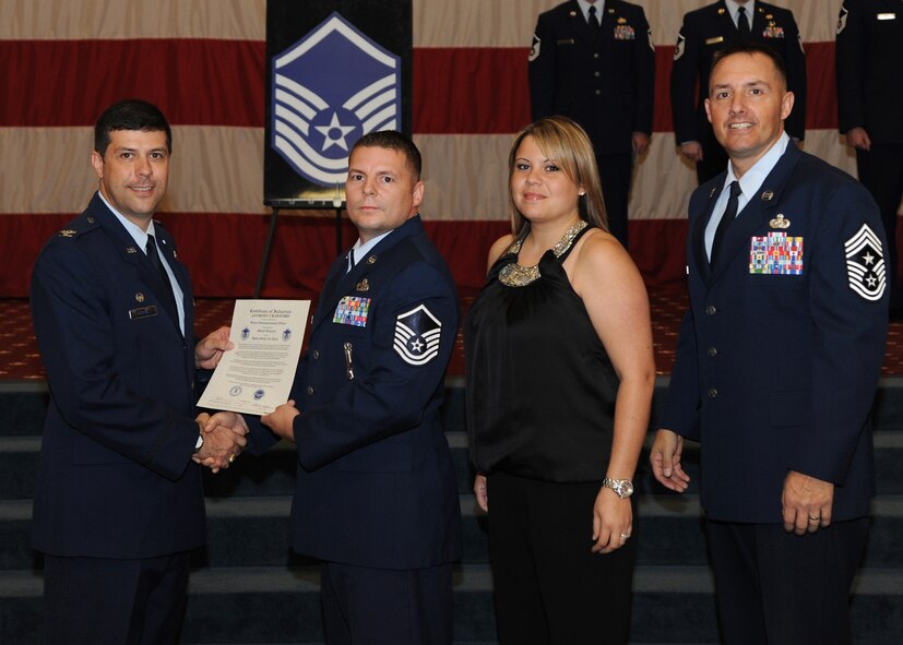 Master Sgt. Anthony Crawford, 2nd Munitions Squadron, receives a certificate of promotion from Col. Andrew Gebara, 2nd Bomb Wing commander, and Chief Master Sgt. Curtis Storms, 2nd BW command chief, during the October Wing Promotion Ceremony on Barksdale Air Force Base, La., Oct. 31, 2013. (U.S. Air Force photo/Senior Airman Joseph A. Pagán Jr.)