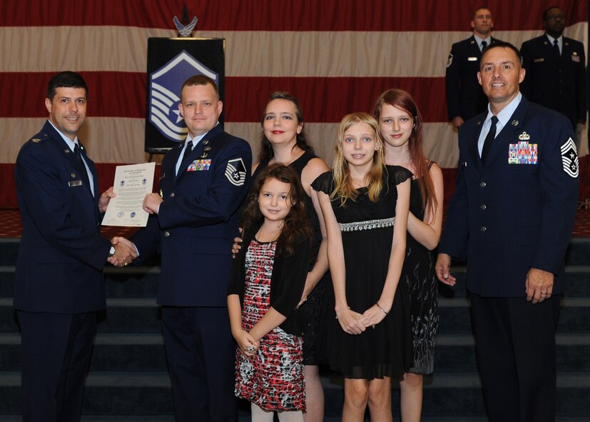 Master Sgt. Jacob Kisor, 2nd Communications Squadron, receives a certificate of promotion from Col. Andrew Gebara, 2nd Bomb Wing commander, and Chief Master Sgt. Curtis Storms, 2nd BW command chief, during the October Wing Promotion Ceremony on Barksdale Air Force Base, La., Oct. 31, 2013. (U.S. Air Force photo/Senior Airman Joseph A. Pagán Jr.)