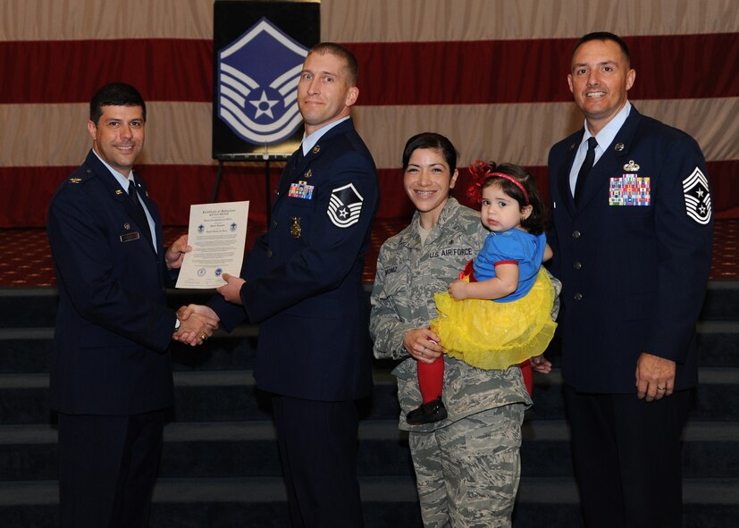 Master Sgt. Kevan Moniz, 2nd Civil Engineer Squadron, receives a certificate of promotion from Col. Andrew Gebara, 2nd Bomb Wing commander, and Chief Master Sgt. Curtis Storms, 2nd BW command chief, during the October Wing Promotion Ceremony on Barksdale Air Force Base, La., Oct. 31, 2013. (U.S. Air Force photo/Senior Airman Joseph A. Pagán Jr.)