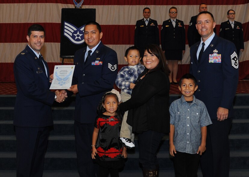 Staff Sgt. Jerrick Poyer, 2nd Force Support Squadron, receives a certificate of promotion from Col. Andrew Gebara, 2nd Bomb Wing commander, and Chief Master Sgt. Curtis Storms, 2nd BW command chief, during the October Wing Promotion Ceremony on Barksdale Air Force Base, La., Oct. 31, 2013. (U.S. Air Force photo/Senior Airman Joseph A. Pagán Jr.)