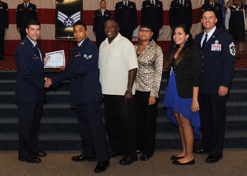 Senior Airman Alexander Swint, 2nd Maintenance Squadron, receives a certificate of promotion from Col. Andrew Gebara, 2nd Bomb Wing commander, and Chief Master Sgt. Curtis Storms, 2nd BW command chief, during the October Wing Promotion Ceremony on Barksdale Air Force Base, La., Oct. 31, 2013. (U.S. Air Force photo/Senior Airman Joseph A. Pagán Jr.)