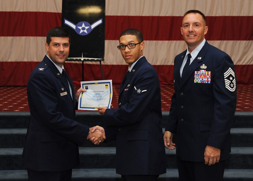 Airman Michael Banks II, 2nd Operations Support Squadron, receives a certificate of promotion from Col. Andrew Gebara, 2nd Bomb Wing commander, and Chief Master Sgt. Curtis Storms, 2nd BW command chief, during the October Wing Promotion Ceremony on Barksdale Air Force Base, La., Oct. 31, 2013. (U.S. Air Force photo/Senior Airman Joseph A. Pagán Jr.)