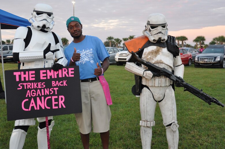 Akeem Slaughter, a volunteer for the Making Strides Against Breast Cancer walk, poses with walkers dressed up as Star Wars Stormtroopers at Space Coast Stadium Oct. 19, 2013. (U.S. Air Force photo/Nelly Slaughter)