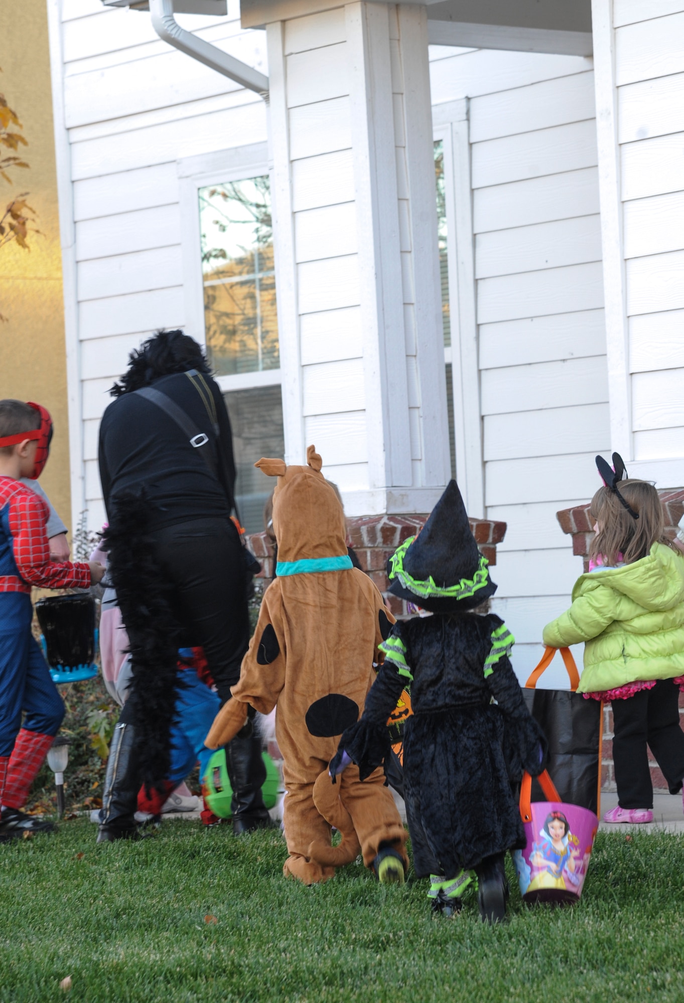 Children go up to a door to collect candy Oct. 31, 2013, in family housing on Buckley Air Force Base, Colo. Children went house to house collecting candy to celebrate Halloween. (U.S. Air Force photo by Staff Sgt. Christopher Gross/Released) 