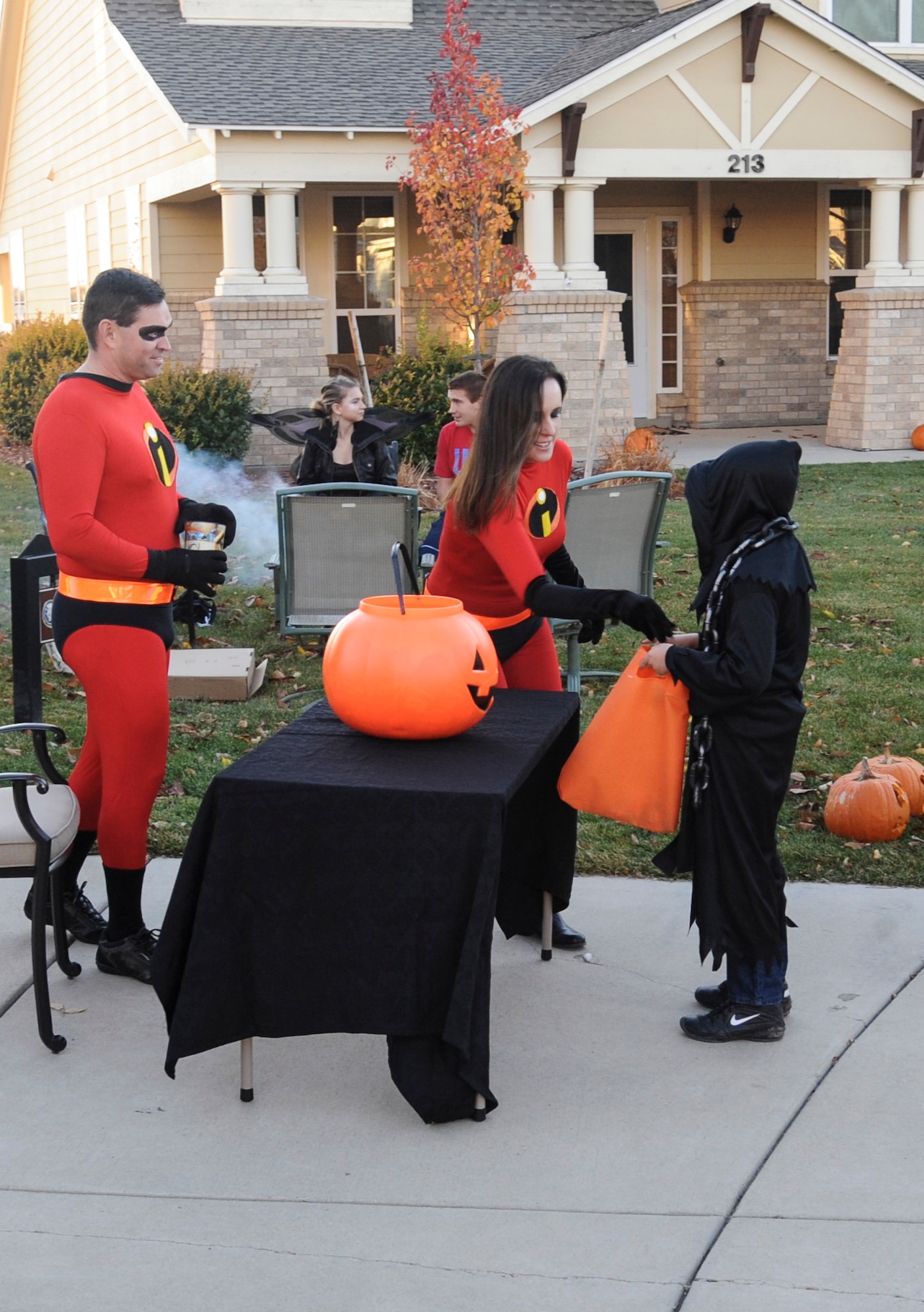 The Saltzman family, dressed as The Incredibles, passes out candy Oct. 31, 2013, in family housing on Buckley Air Force Base, Colo. Children went house to house collecting candy to celebrate Halloween. (U.S. Air Force photo by Staff Sgt. Christopher Gross/Released) 