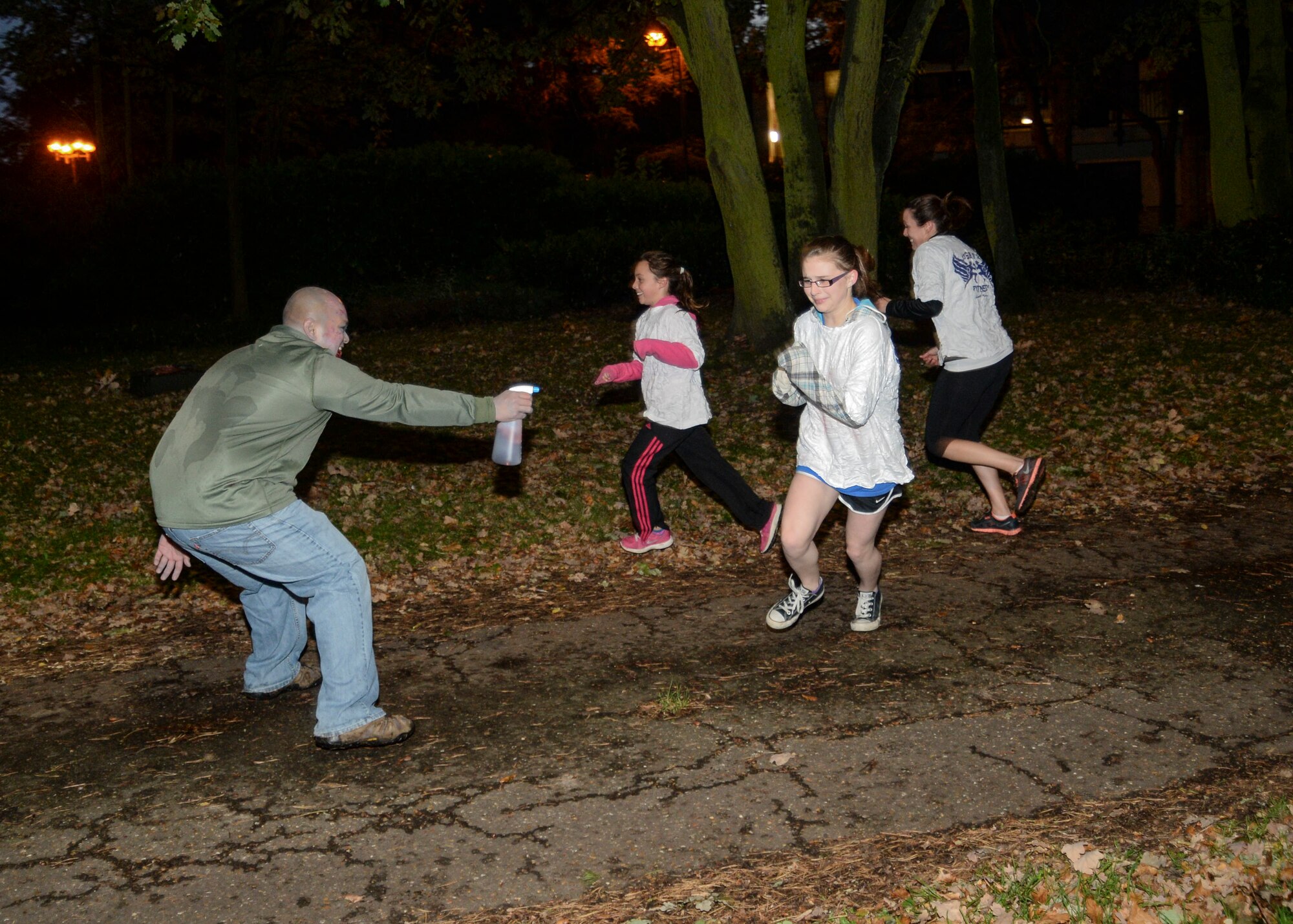 Zombie “get ya’s” spray Halloween Zombie Run participants at the base track on Royal Air Force Lakenheath, England, Oct. 31, 2013. Runners participated in a 30-minute course around the installation while evading “get ya” zombies blocking their paths. (U.S. Air Force photo by Airman 1st Class Nigel Sandridge/Released)