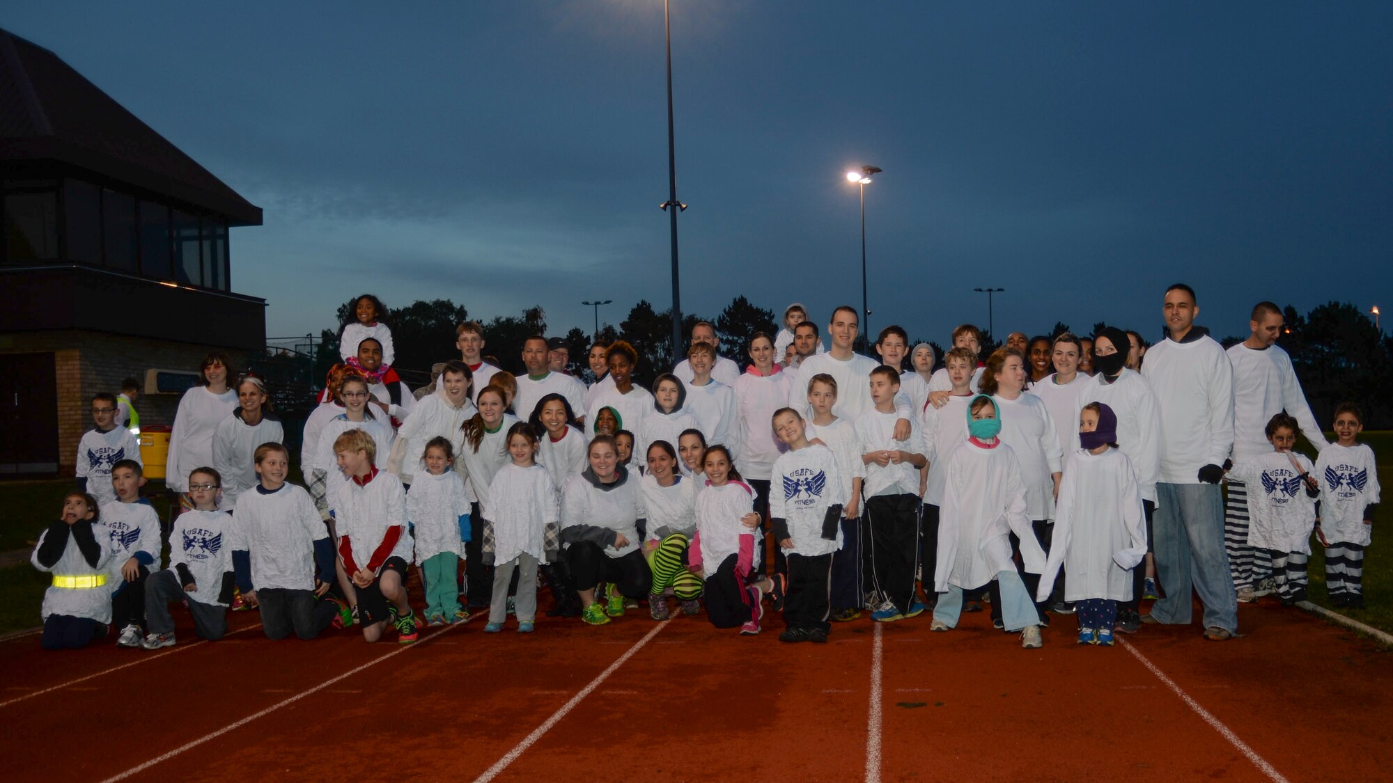 Liberty Airmen and family members take a group photo before beginning the Halloween Zombie Run at the base track on Royal Air Force Lakenheath, England, Oct. 31, 2013. Runners participated in a 30-minute course around the installation while evading “get ya” zombies blocking their paths. (U.S. Air Force photo by Airman 1st Class Nigel Sandridge/Released)