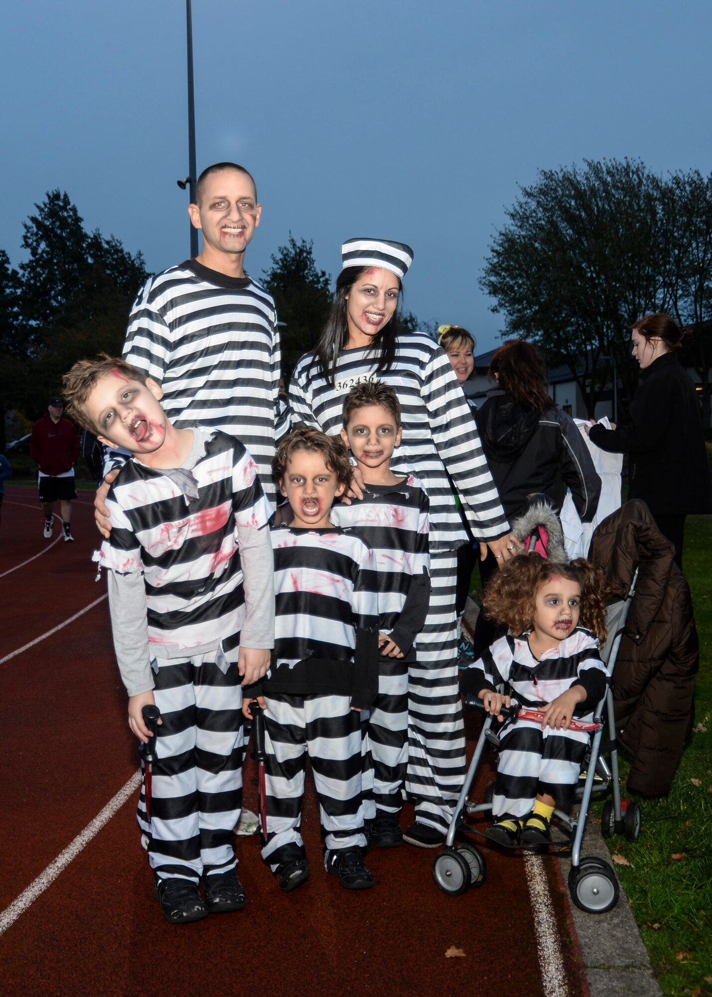 The Wiggington family dress up as zombie prisoners during the Halloween Zombie Run at the base track on Royal Air Force Lakenheath, England, Oct. 31, 2013. Runners participated in a 30-minute course around the installation while evading “get ya” zombies blocking their paths. (U.S. Air Force photo by Airman 1st Class Nigel Sandridge/Released)