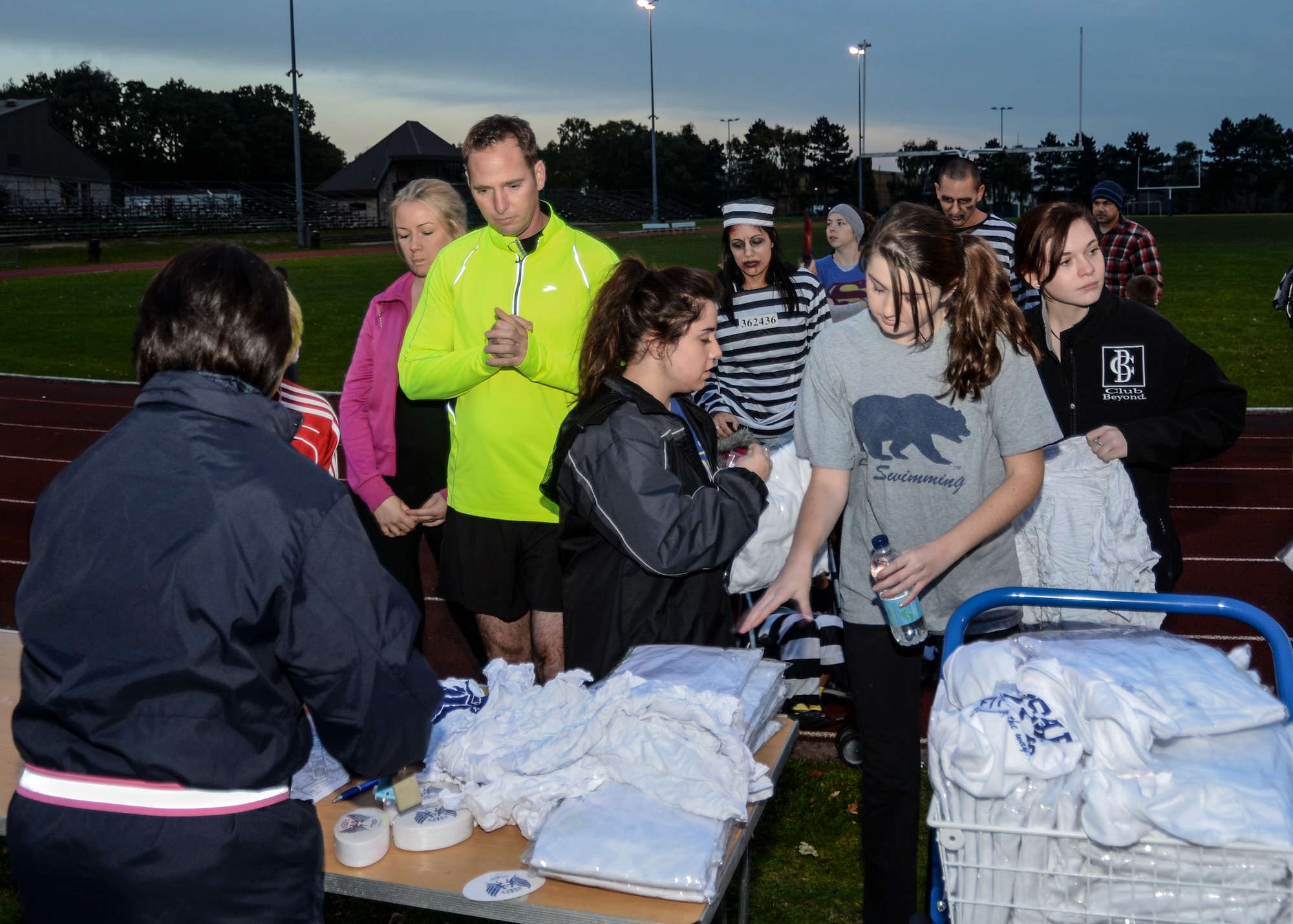 Liberty Airmen and family members sign up for the Halloween Zombie Run and receive complimentary t-shirts at the base track on Royal Air Force Lakenheath, England, Oct. 31, 2013. Runners participated in a 30-minute course around the installation while trying to evade “get ya” zombies throughout the path. (U.S. Air Force photo by Airman 1st Class Nigel Sandridge/Released)