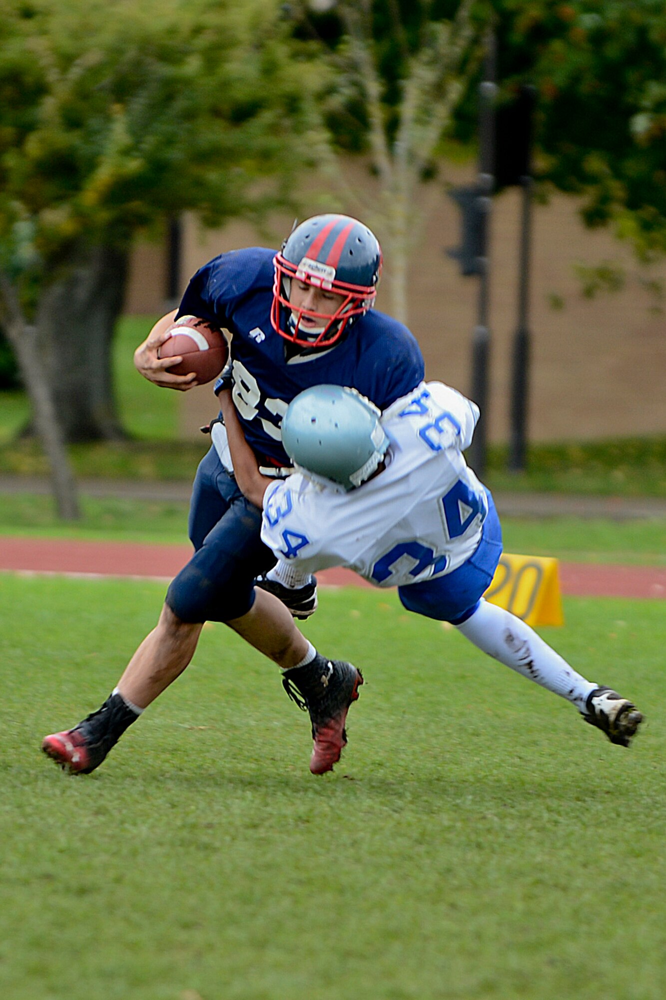 Rane Stringer (83), Lakenheath High School Junior Varsity Lancers wide receiver, runs through a Brussels American School football team member during a game at the Royal Air Force Lakenheath, England, football field Oct. 26, 2013. The Lancers lost 42-0, but Stringer recorded 15 receptions for 144 yards and a touchdown throughout the season. (U.S. Air Force photo by Airman 1st Class Trevor T. McBride/Released)