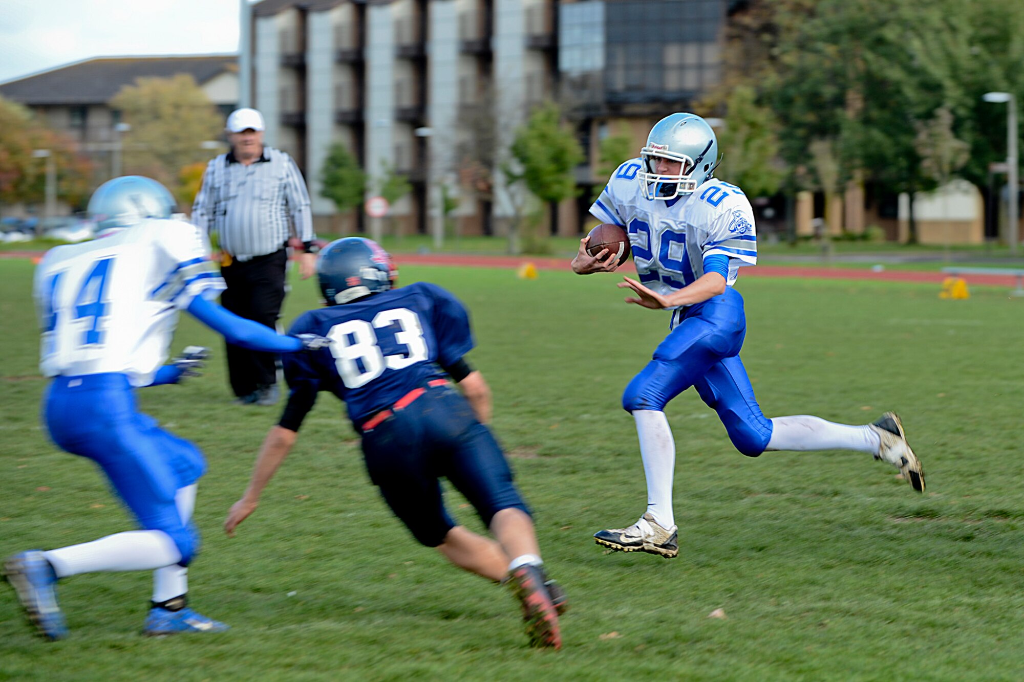 A Brussels American School football team member (white) runs from a Lakenheath High School Junior Varsity Lancers defender at the Royal Air Force Lakenheath, England, football field Oct. 26, 2013. The Lancers lost 42-0 but look forward to a more successful 2014 football season.  (U.S. Air Force photo by Airman 1st Class Trevor T. McBride/Released)