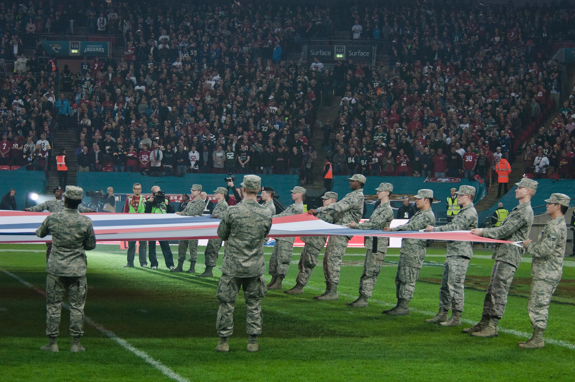 Airmen from Royal Air Force Lakenheath, England, hold a U.K. flag at Wembley Stadium, London, just prior to kick-off, at the NFL International Series game between the San Francisco 49ers and Jacksonville Jaguars Oct. 27, 2013. The pregame pageantry also included a joint forces honor guard from RAF Feltwell and a performance by recording artist Ne-Yo. (U.S. Air Force photo by 2nd Lt. Keenan Kunst/Released) 