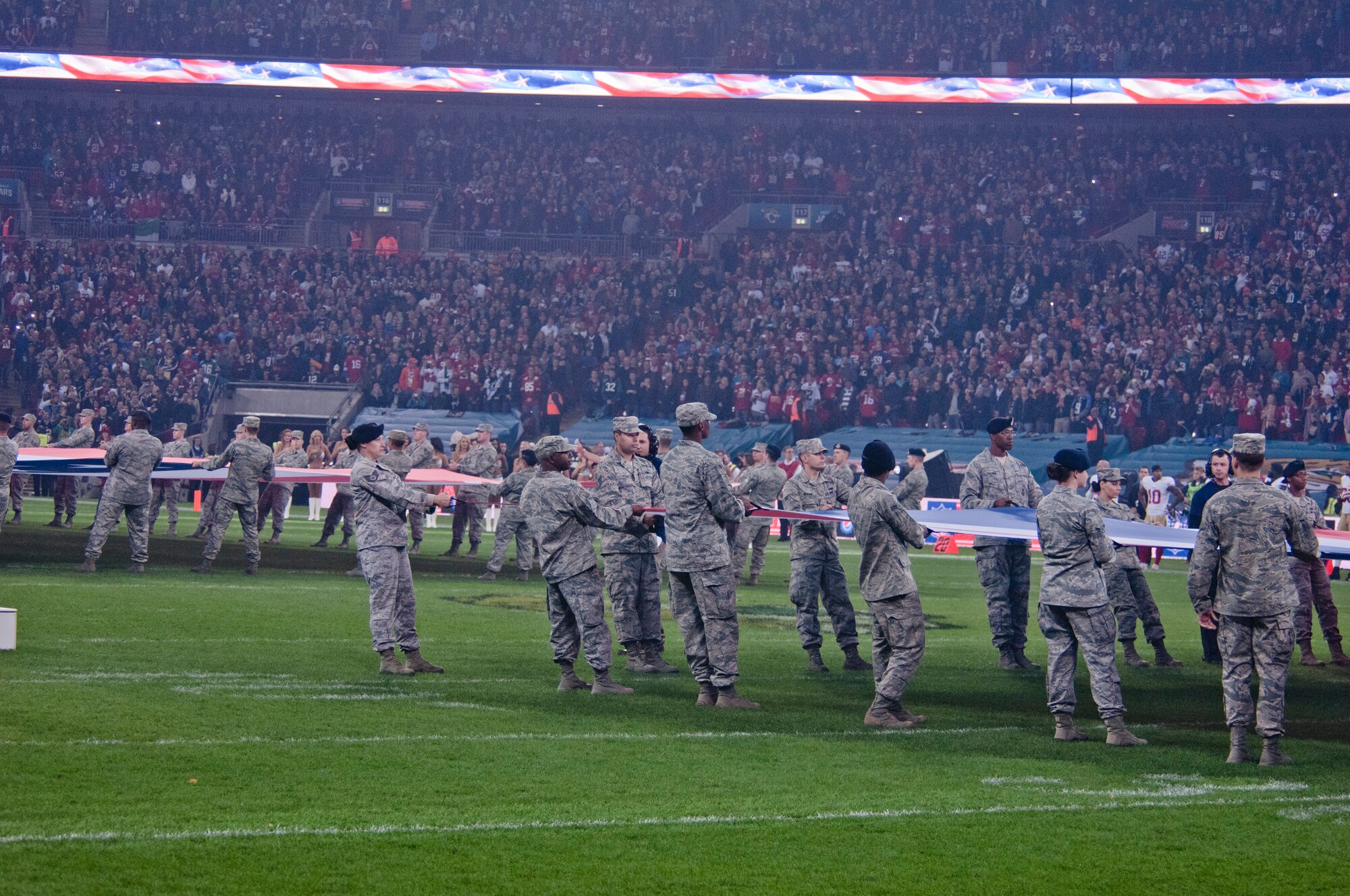 Airmen from Royal Air Force Lakenheath, England, hold the U.S. and U.K. flags at Wembley Stadium, London, just prior to kick-off, at the NFL International Series game between the San Francisco 49ers and Jacksonville Jaguars Oct. 27, 2013. The pregame pageantry also included a joint forces honor guard from RAF Feltwell and a performance by recording artist Ne-Yo. (U.S. Air Force photo by 2nd Lt. Keenan Kunst/Released) 