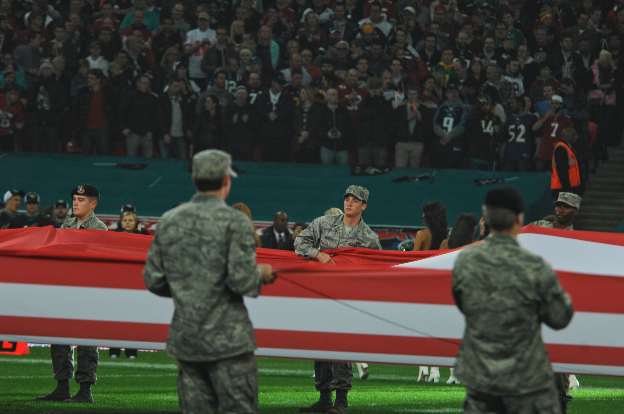 Liberty Wing Airmen hold a giant U.S. flag on the field at Wembley Stadium, London, as part of the pregame ceremony for the NFL International Series game between the San Francisco 49ers and Jacksonville Jaguars Oct. 27, 2013. The pregame pageantry also included a joint forces honor guard from Royal Air Force Feltwell and a performance by recording artist Ne-Yo. (U.S. Air Force photo by 2nd Lt. Keenan Kunst/Released)