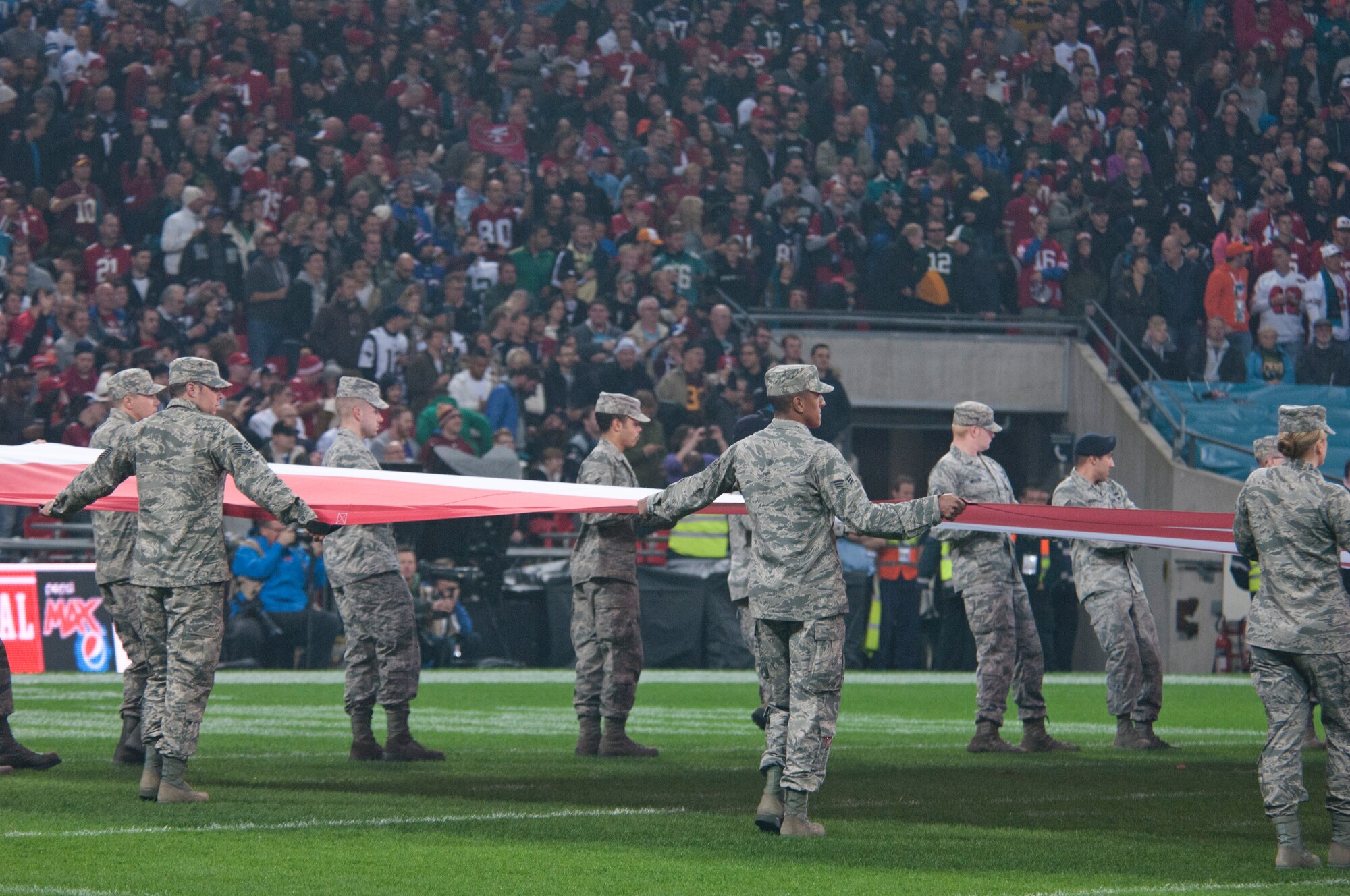 Airmen from Royal Air Force Lakenheath, England, hold the U.S. flag at the San Francisco 49ers – Jacksonville Jaguars game Oct. 27, 2013. The game was part of the NFL’s International Series at Wembley Stadium, London.  As part of the pregame ceremony, 48th Fighter Wing Airmen held giant U.K. and U.S. flags, and RAF Feltwell provided a joint honor guard.  (U.S. Air Force photo by 2nd Lt. Keenan Kunst/Released)