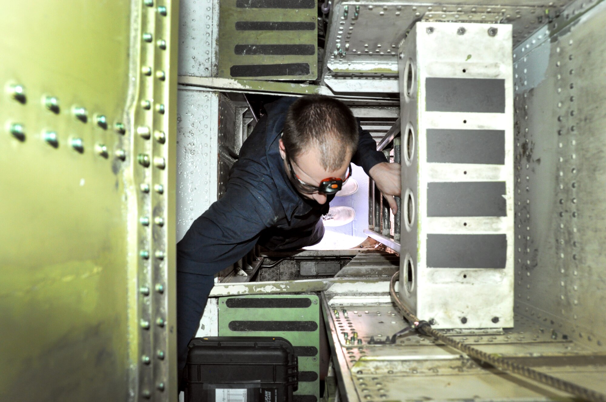 Senior Airman Gene Shorter, 60th Maintenance Squadron non-destructive inspections technician, climbs into the access port to inspect the elevator control box on a KC-10 Extender Oct. 22. (U.S. Air Force photo/Staff Sgt. Patrick Harrower)