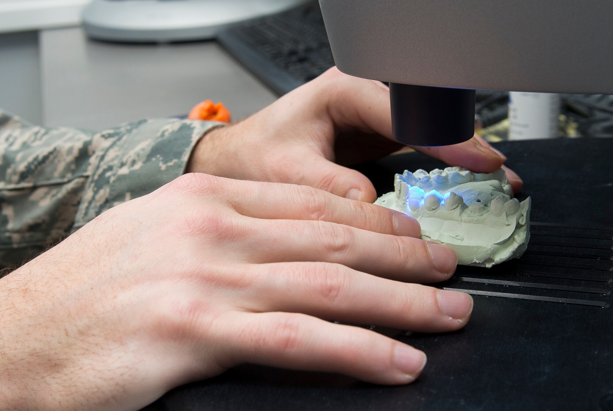 Tech. Sgt. Charles Davis, 86th Dental Squadron fixed element leader, places a mold of a patient’s mouth into a 3-D scanner to use software to design and mill a crown, Oct. 29, 2013, Ramstein Air Base, Germany. The computer assisted design and manufacture of dental crowns enables dentists to have crowns finished in one day instead of 28 days. (U.S. Air Force photo/Senior Airman Jose L. Leon)