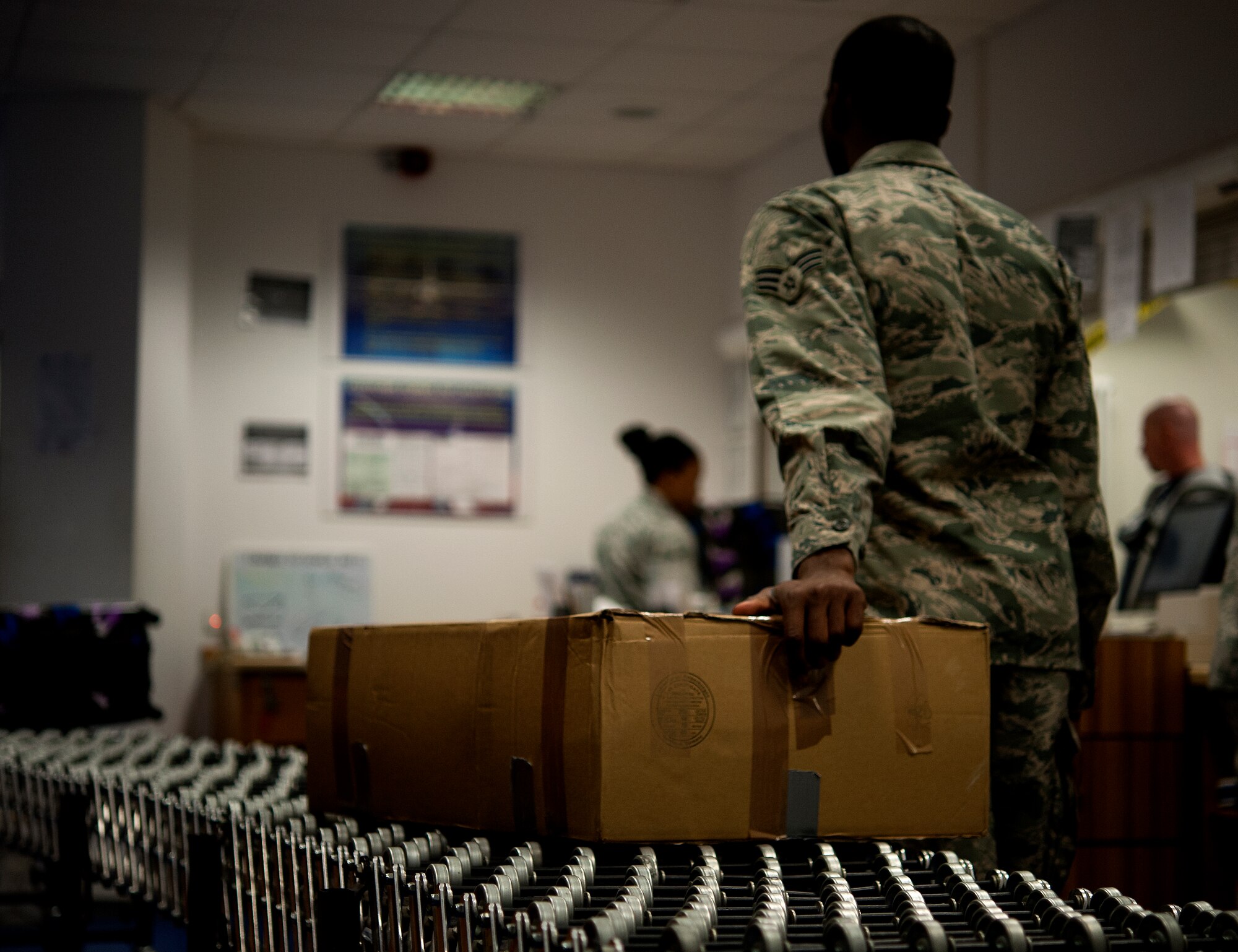 Senior Airman Jonathan Lee, 86th Communications Squadron finance clerk, moves a package to the delivery area at the Northside Post Office Oct. 24, 2013, Ramstein Air Base, Germany. As the holidays approach, Airmen working at the post office will work longer hours to ensure operations continue to run smoothly. (U.S. Air Force photo/Senior Airman Damon Kasberg)