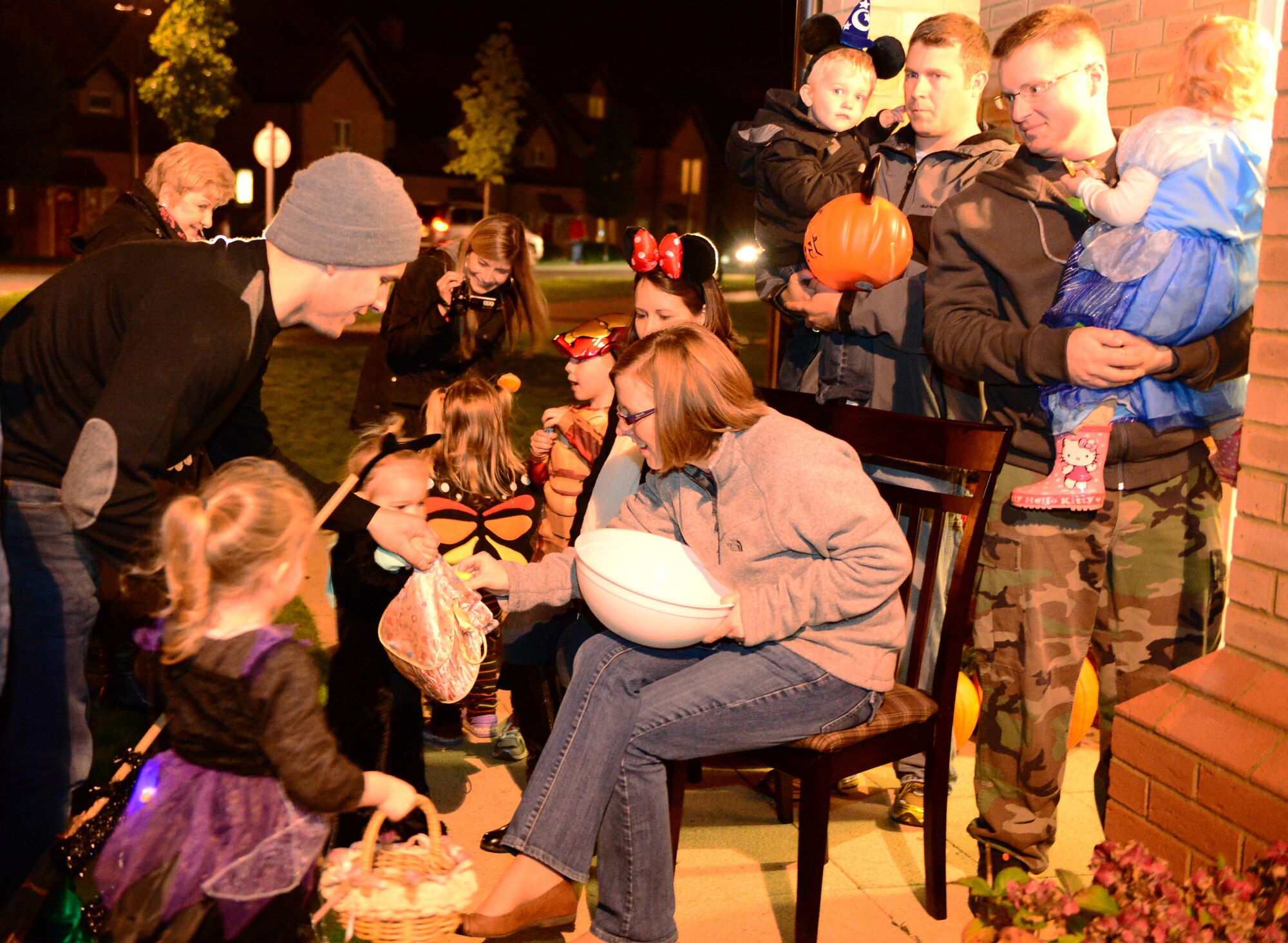 Heather Douglass, Airman and Family Readiness Center wing volunteer coordinator, and her husband, Tech. Sgt. Scott Douglass, 372nd Training Squadron instructor, hand out candy to trick-or-treaters on Royal Air Force Lakenheath, England, Oct. 31, 2013. Residents of Liberty Village opened their doors to parents and children to promote a safe Halloween. (U.S. Air Force photo by Airman 1st Class Dawn M. Weber/Released)