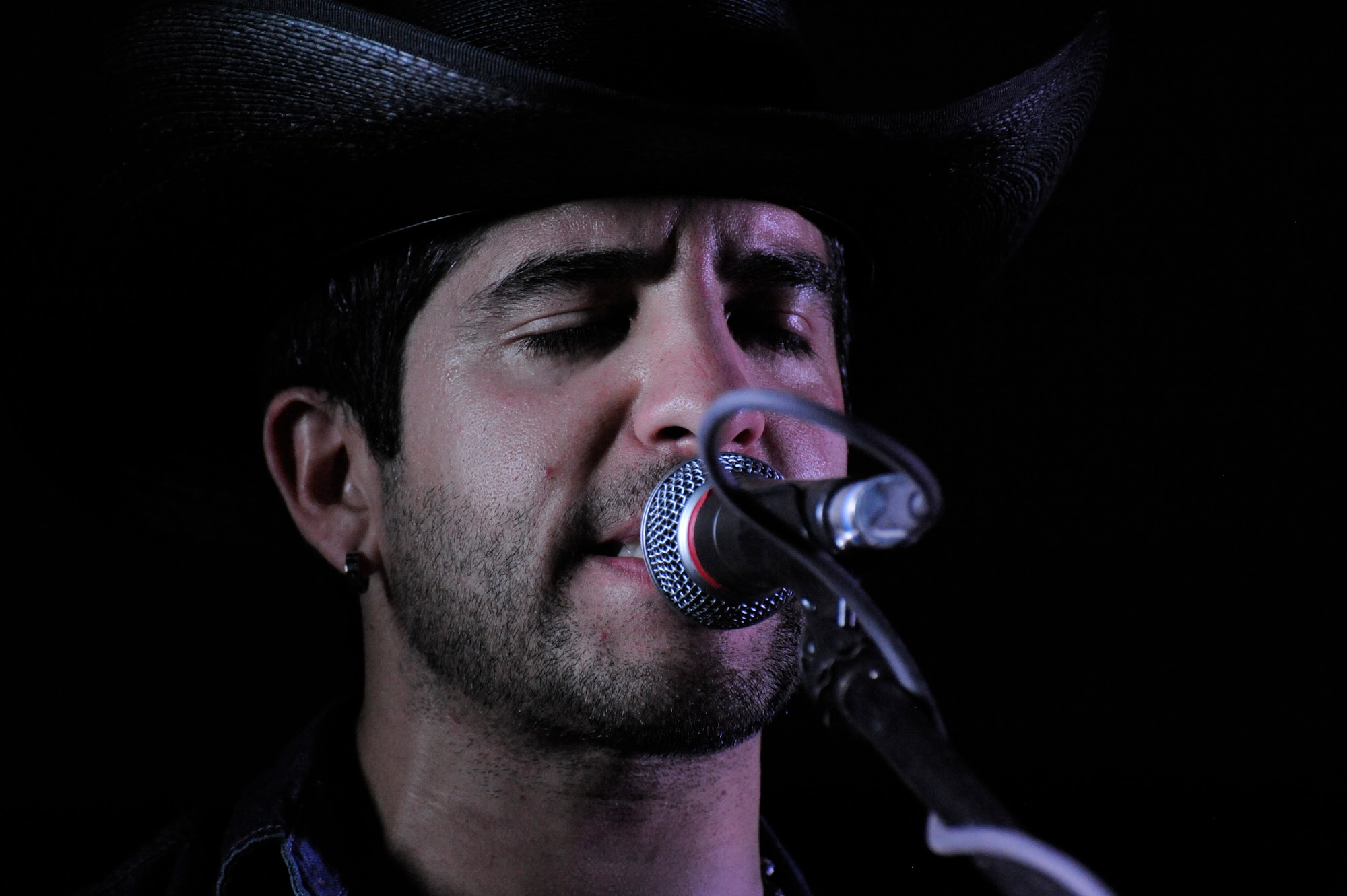 Charles Longoria, a “Lost Trailers” guitarist and band leader, sings during a performance at the 379th Air Expeditionary Wing in Southwest Asia, Oct. 31, 2013. During the 379th Expeditionary Force Support Squadron hosted event, the American country band expressed their gratitude for military service members. (U.S. Air Force photo/Senior Airman Bahja J. Jones) 