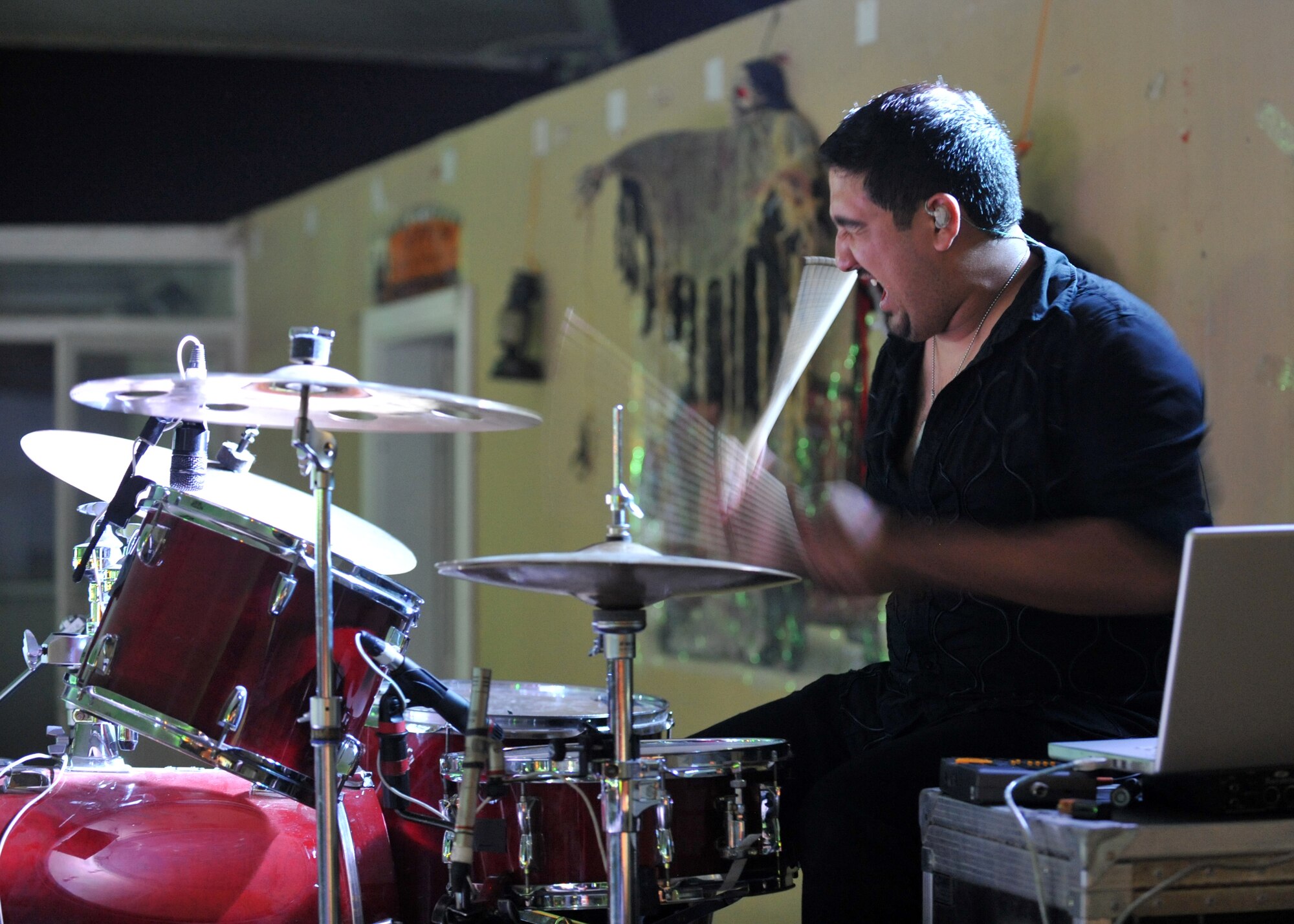 The Lost Trailers drummer, Eric Flores, gets into the music during a performance at the 379th Air Expeditionary Wing in Southwest Asia. During the 379th Expeditionary Force Support Squadron hosted event, the American country band expressed their gratitude for military service members. (U.S. Air Force photo/Tech. Sgt. Joselito Aribuabo) 