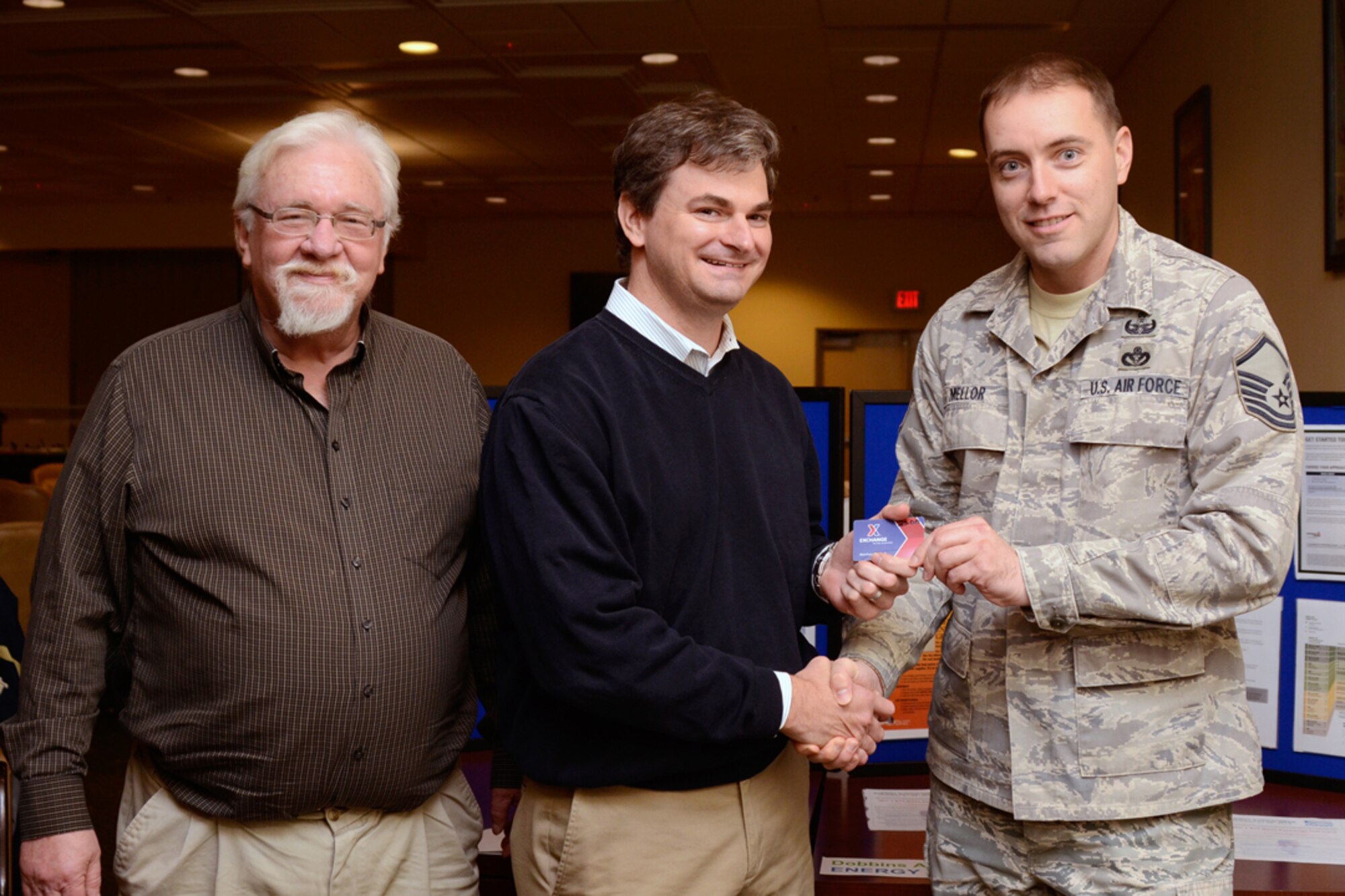Master Sgt. Jason A. Mellor, 94th Explosive Ordnance Disposal craftsman, is presented a $25 Base Exchange Gift Card from Paul Eskew and Hugh Phillips of base civil engineering after participating in an Energy Action Week Trivia and Drawing Oct. 24 at the base consolidated club. Dobbins Energy Action Week took place Oct. 21 thru 25, and consisted of awareness, trivia, prizes and members of base civil engineering offering members ways to save energy and resources in their home as well as work areas. (U.S. Air Force photo/Don Peek)