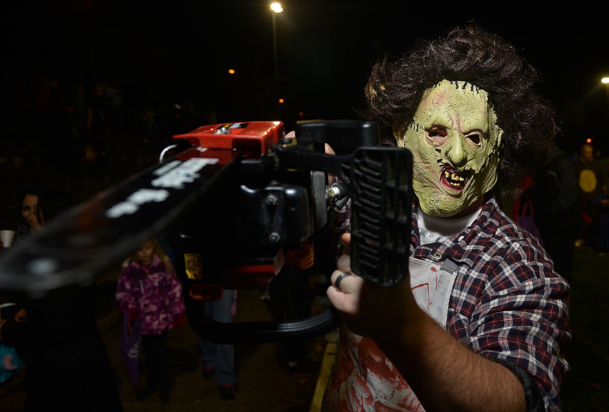 Army Sgt. Ryan Kniss, Defense Courier Service DOD courier, attacks an unprepared photographer during the 2013 Halloween Trunk or Treat at Donnely Park, Oct. 31, 2013, Ramstein Air Base, Germany. Trunk or Treat featured goblins, ghouls, monsters, minions, aliens, and dinosaurs, as well as food, games, movies, costume contests and trunks full of candy for eager trick-or-treaters. (U.S. Air Force photo/Airman 1st Class Jordan Castelan)