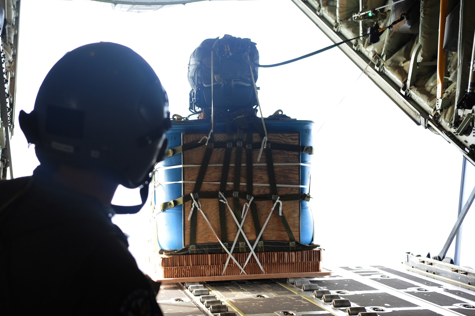 Master Sgt. Jason Beebe, 37th Airlift Squadron loadmaster, drops a bundle with the Joint Precision Airdrop System attached to test the capabilities of the system before active employment, Oct. 23, 2013, Powidz Air Transport Base, Poland. The JPADS is equipped with a GPS, allowing the bundles to land within feet of the point of impact, ensuring they get to war fighters. (U.S. Air Force photo/Senior Airman Hailey Haux)