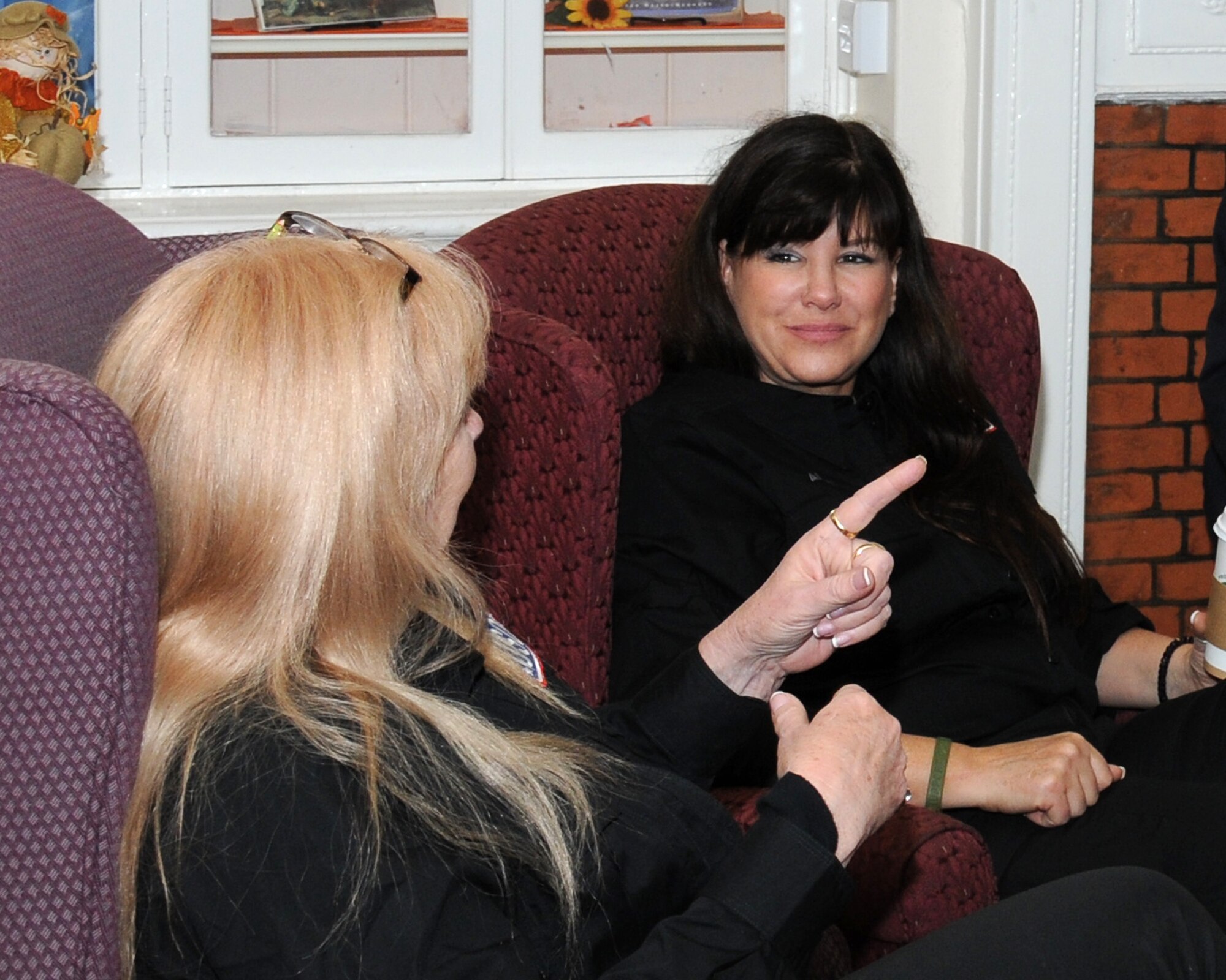 Kathleen Antrim, right, and Heather Graham, both authors, take part in a USO-sponsored book-signing event  Oct. 31, 2013, at the library on RAF Mildenhall, England. The tour also visited the U.S., Kuwait and Germany. The authors took time to sign books and talk with Team Mildenhall members and their families. (U.S. Air Force photo by Gina Randall/Released)