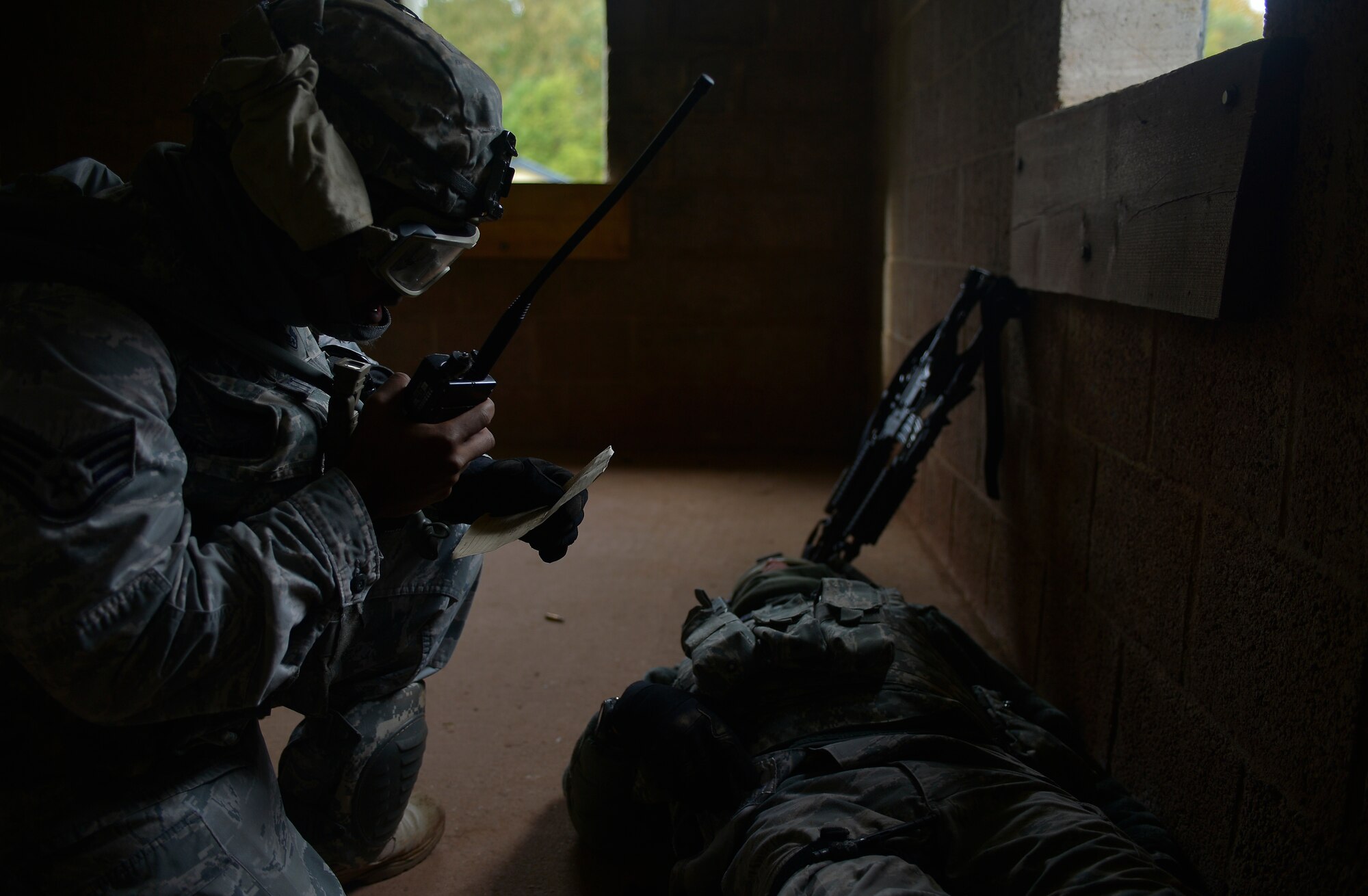 Staff Sgt. Tony Pettway, 355th Security Forces Squadron creek defender course trainee, calls in a medical evacuation for Airman 1st Class Jose Ramos, 355th SFS creek defender course trainee, during building clearance training, Oct. 17, 2013, Baumholder, Germany. Pettway was part of a 98-student class undergoing training to prepare them for deployed conditions around the world. (U.S. Air Force photo/Airman 1st Class Jordan Castelan) 