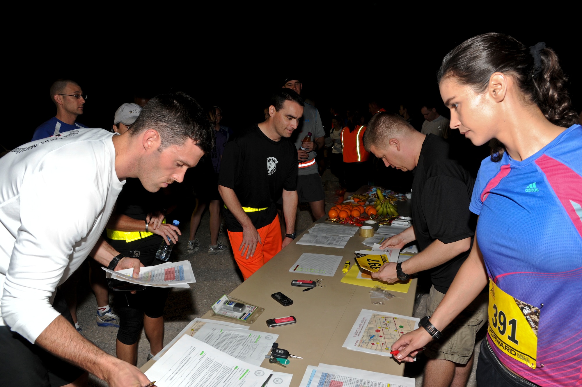 Volunteers assist marathon runners with registration documents during the Special Operations Command Central Forward Marine Corps Marathon at the 379th Air Expeditionary Wing in Southwest Asia, Oct. 27, 2013.  The 26.2-mile run mirrored the 38th Marine Corps Marathon held each year in Washington D.C. (U.S. Air Force photo/Tech. Sgt. Joselito Aribuabo)