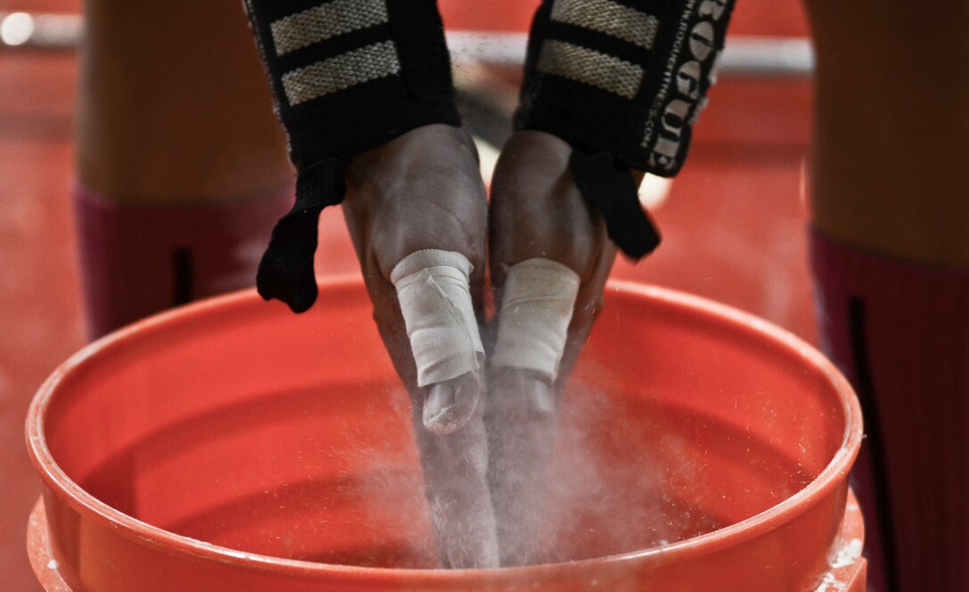 Staff Sgt. Stephen Baker, 736th Security Forces Squadron parachute program manager and CrossFit Andersen community involvement and event coordinator, chalks his hands before lifting weights Oct. 26, 2013, during the barbells for breast cancer awareness event at the Hot Spot on Andersen Air Force Base, Guam. Participants did some heavy-duty lifting to raise breast cancer awareness and promote the importance of exercise in maintaining good health. (U.S. Air Force photo by Senior Airman Marianique Santos/Released)
