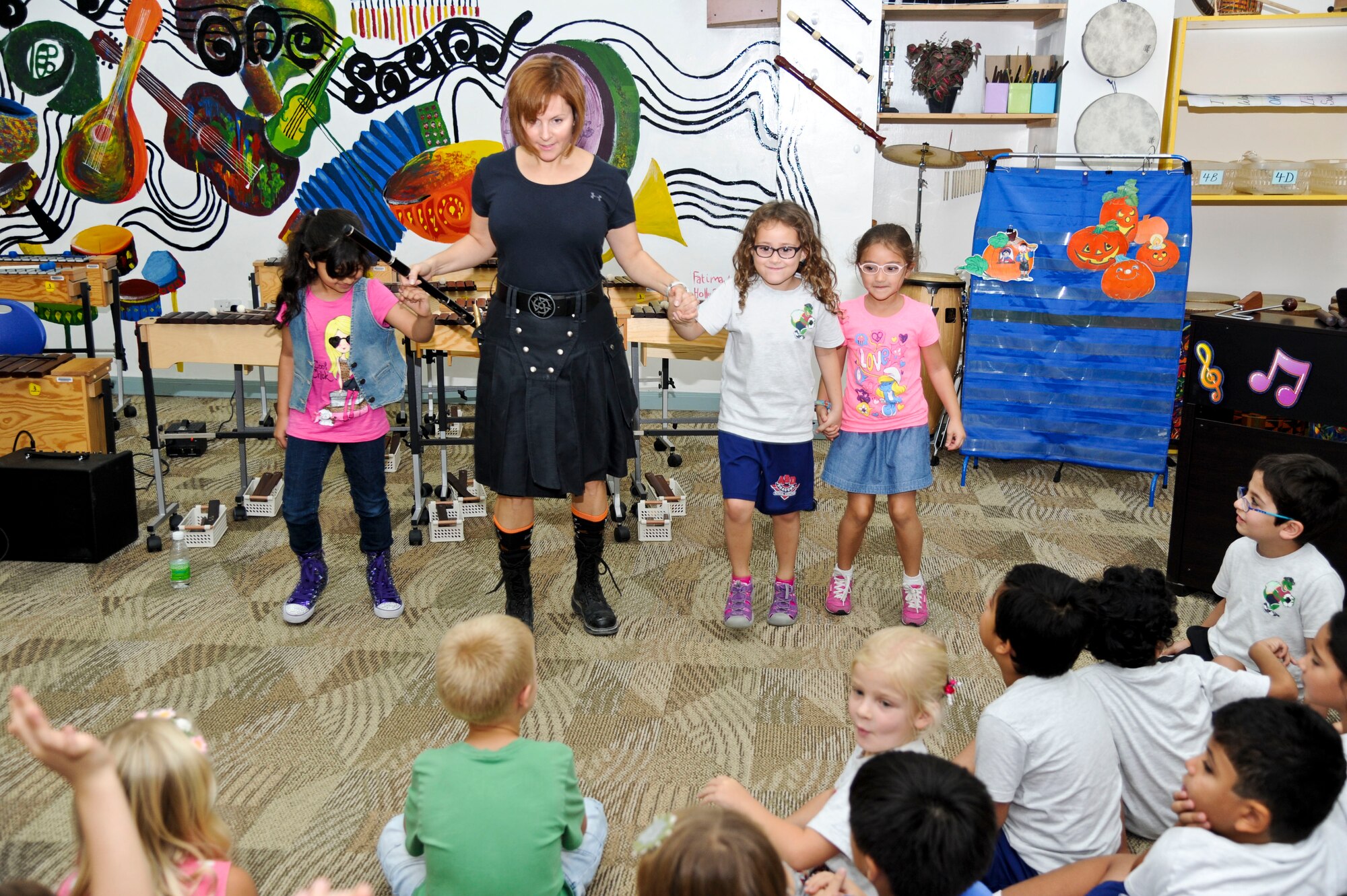 Master Sgt. Sherry Burt from U.S. Air Forces Central Band the “Blue Yonders,” dances with elementary students during a performance at a local school in Southwest Asia, Oct. 28, 2013. The AFCENT band’s mission is to positively promote troop morale, diplomacy and outreach to host nation communities.  Burt is the AFCENT band NCO in charge deployed from Travis Air Force Base, Calif., and a native of Chattanooga, Tenn. (U.S. Air Force photo/Tech. Sgt. Joselito Aribuabo)