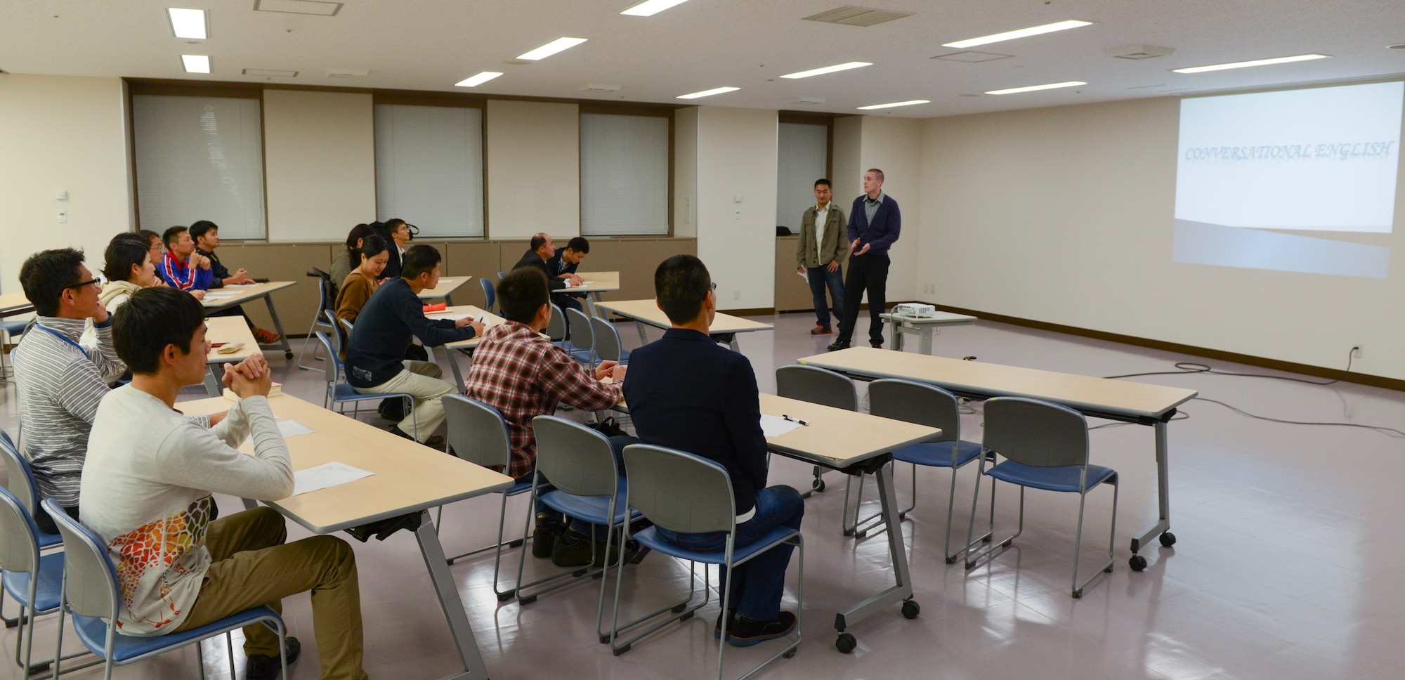 Two Airmen volunteers begin a conversational English class for a group of Japan Air Self-Defense Force members at Yokota Air Base, Japan, Oct. 30, 2013. The class is led by 10 volunteers from both on and off base. (U.S. Air Force photo by Senior Airman Michael Washburn/Released)