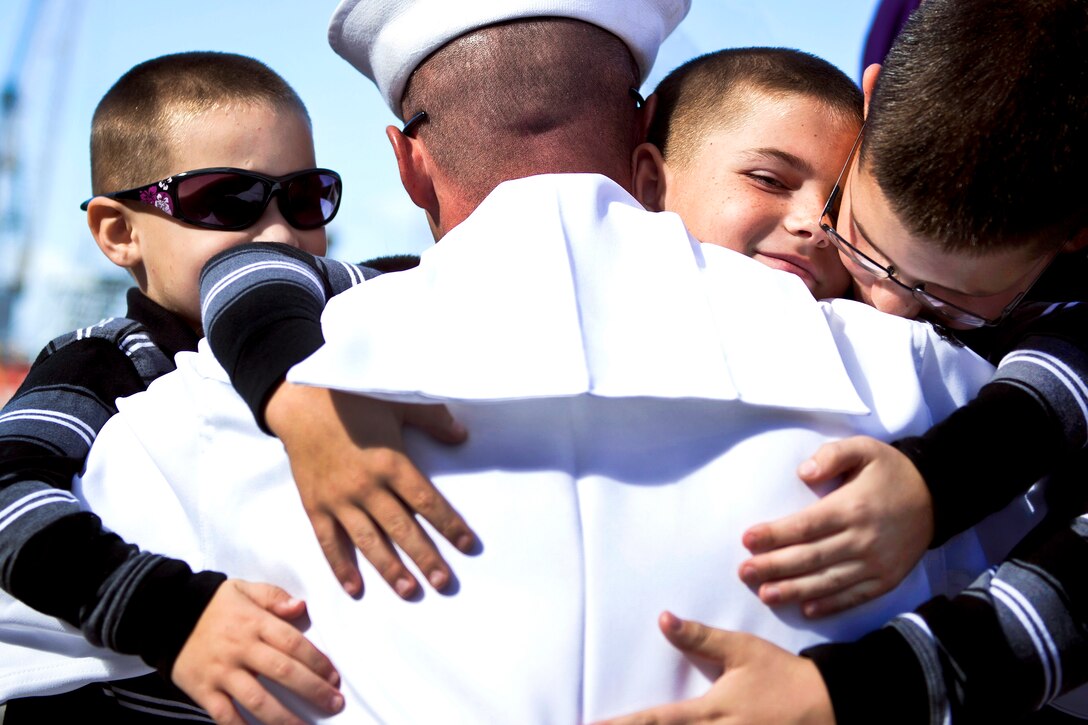 Navy Petty Officer Engineman 1st Class Kevin Ives, assigned to the guided-missile cruiser USS Princeton, embraces his sons during a homecoming celebration on Naval Base San Diego, Oct. 29, 2013. The  Princeton conducted maritime security operations, theater security cooperation efforts and support missions for Operation Enduring Freedom.